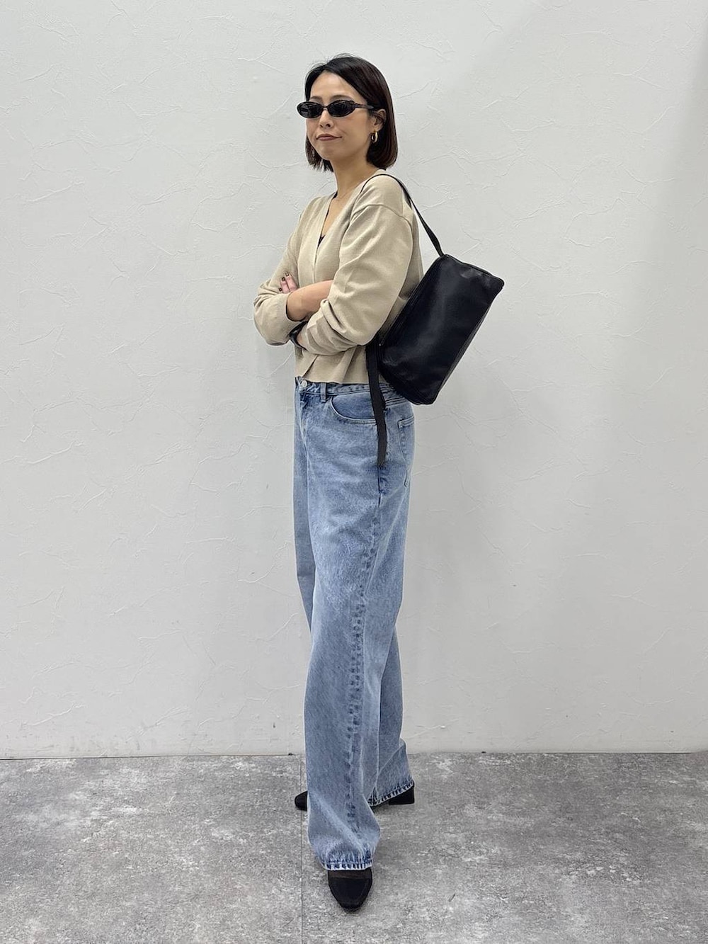 ブラック系のショルダーバッグ、ゴールド系のピアス（両耳用）、ゴールド系のリングを着用したレディースの冬コーディネートの4枚目の写真