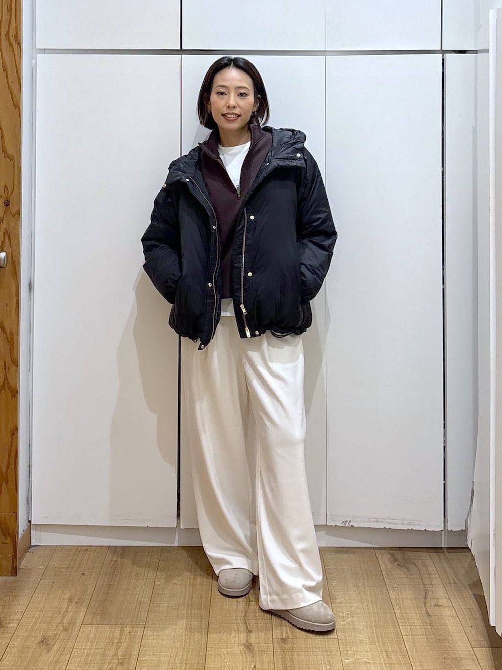 ブラック系のダウンジャケット/コート、ホワイト系のTシャツ/カットソー、グレー系のその他パンツを着用したレディースの冬コーディネートの2枚目の写真