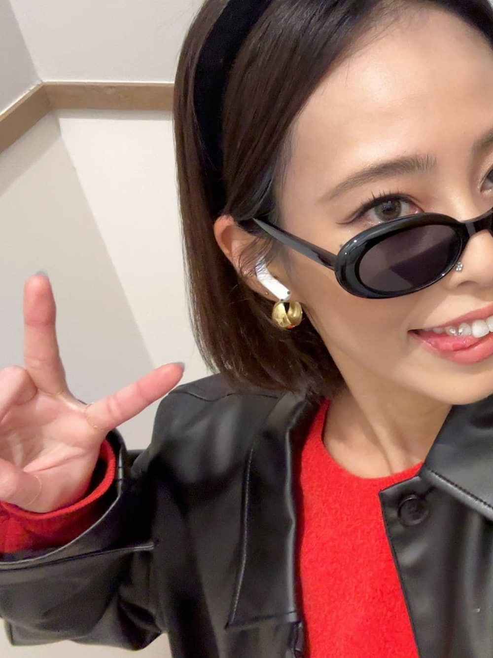 ブラック系のブルゾン、レッド系のニット/セーター、ブラック系のカチューシャを着用したレディースの秋コーディネートの3枚目の写真