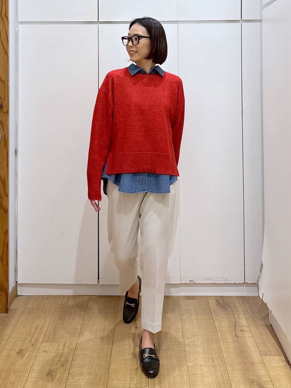 ブラック系のローファー、ブルー系のシャツ/ブラウス、レッド系のニット/セーターを着用したレディースの冬コーディネートの2枚目の写真