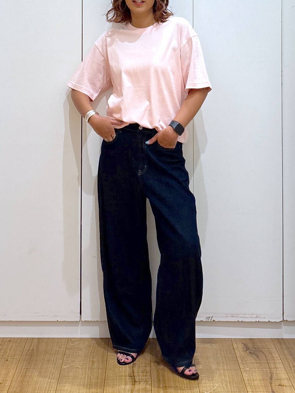 ブルー系のデニムパンツ、ピンク系のTシャツ/カットソー、ブラック系のサンダルを着用したレディースの夏コーディネートの4枚目の写真