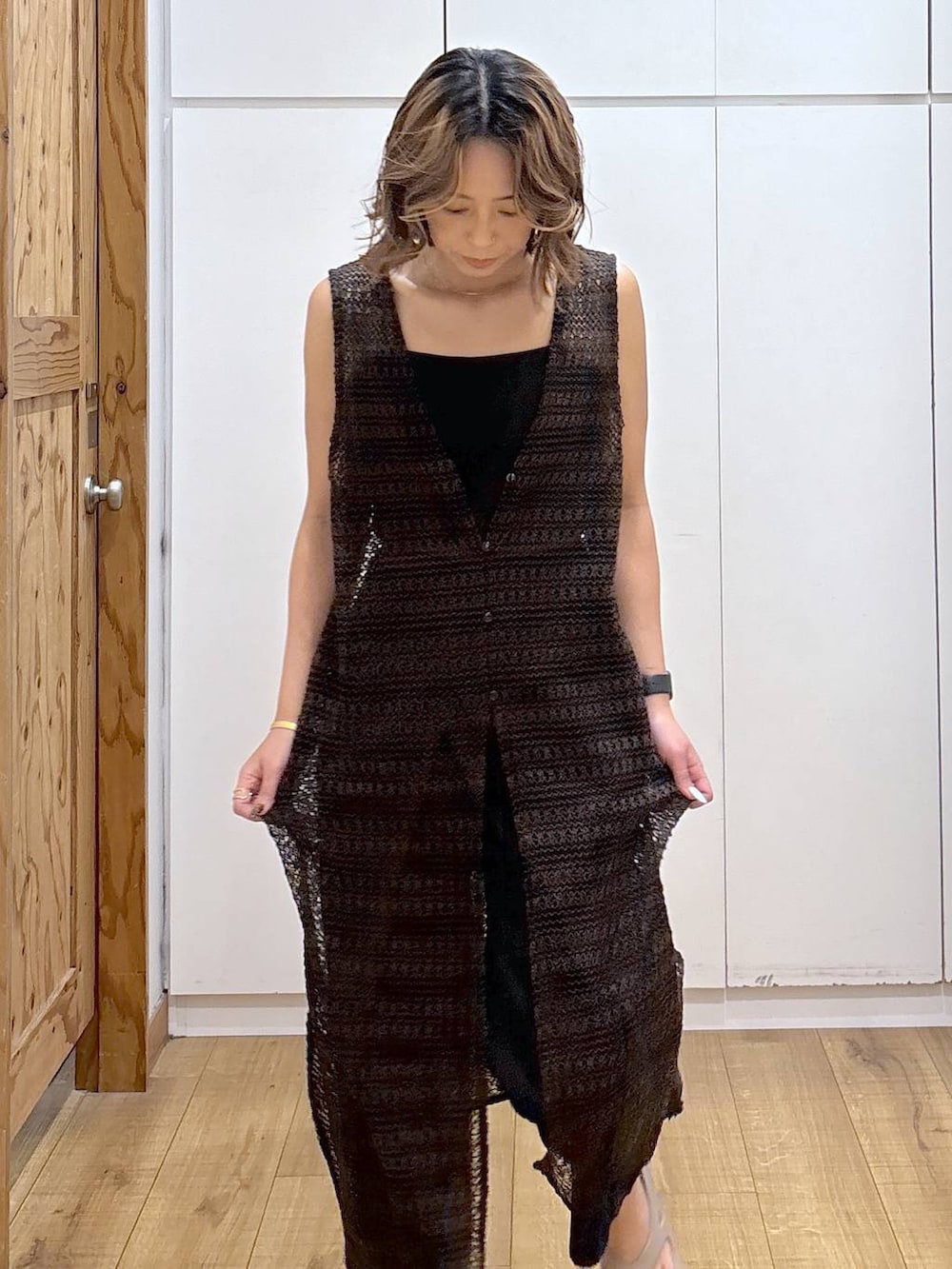 ブルー系のデニムパンツ、ブラック系のキャミソール、ベージュ系のサンダルを着用したレディースの夏コーディネートの4枚目の写真