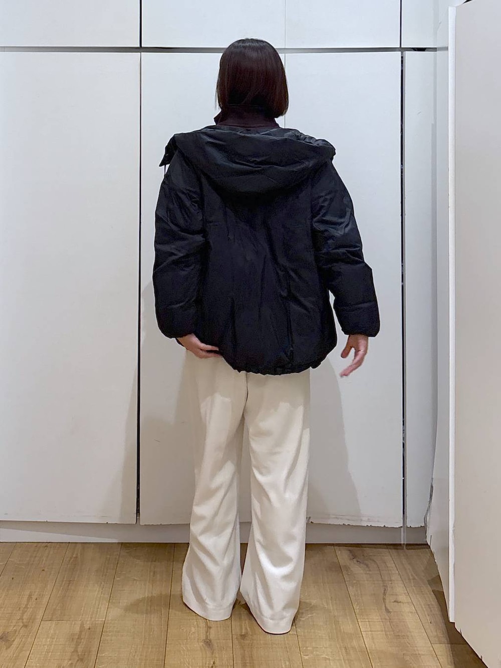 ブラック系のダウンジャケット/コート、ホワイト系のTシャツ/カットソー、グレー系のその他パンツを着用したレディースの冬コーディネートの5枚目の写真