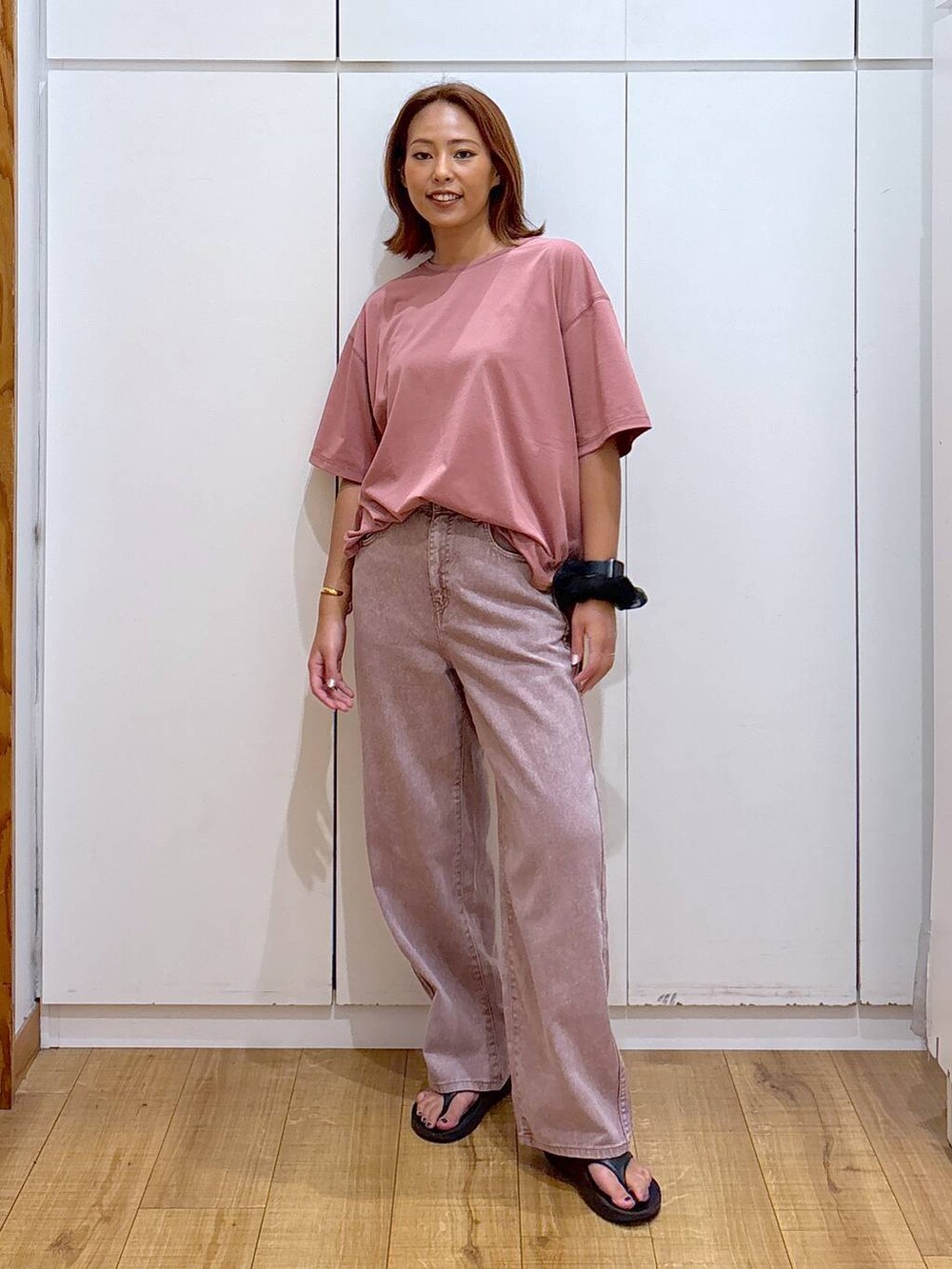 ピンク系のデニムパンツ、ピンク系のTシャツ/カットソー、ブラック系のサンダルを着用したレディースの夏コーディネートの3枚目の写真