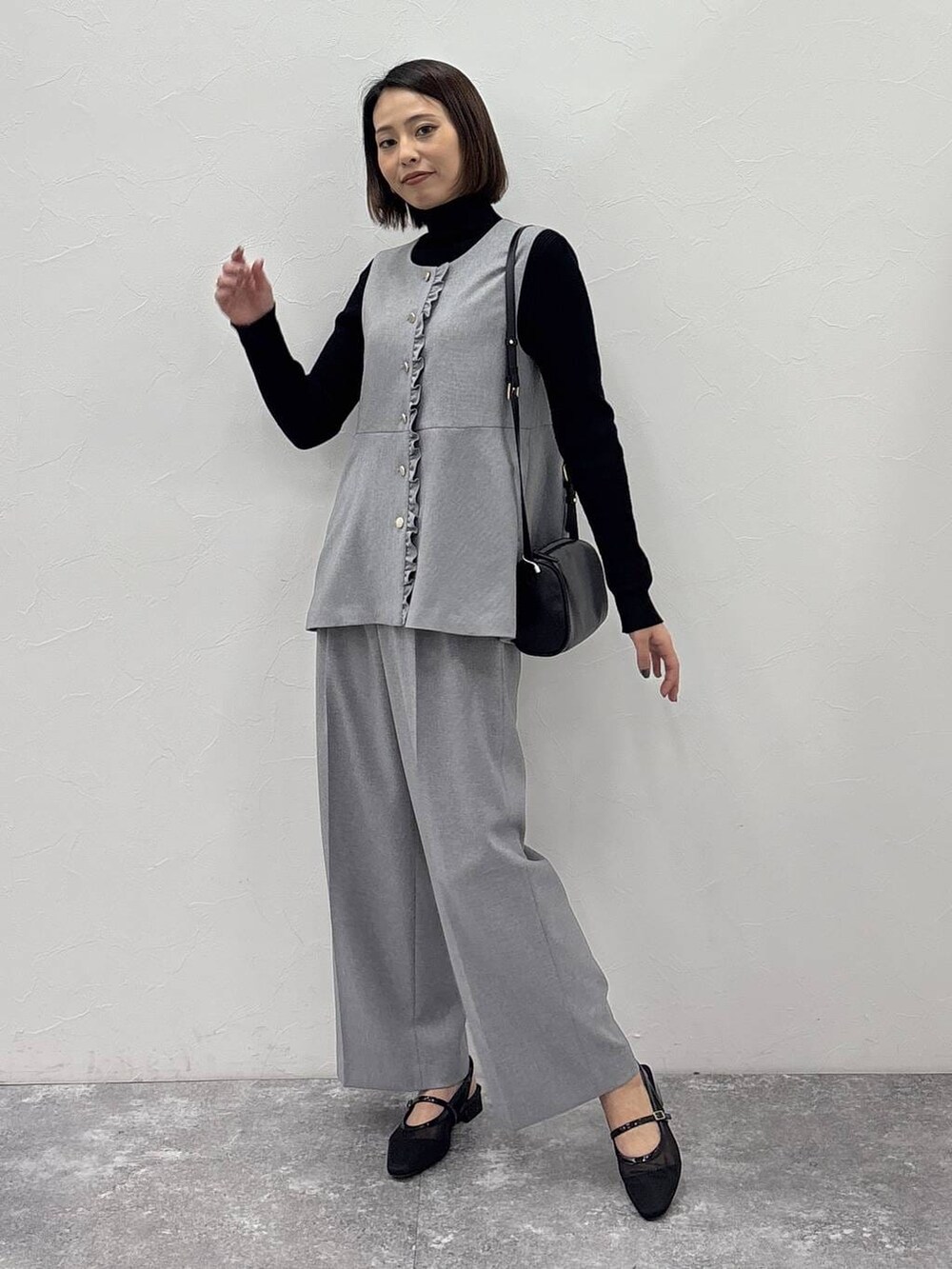 ブラック系のニット/セーター、グレー系のその他パンツ、グレー系のベストを着用したレディースの冬コーディネートの2枚目の写真