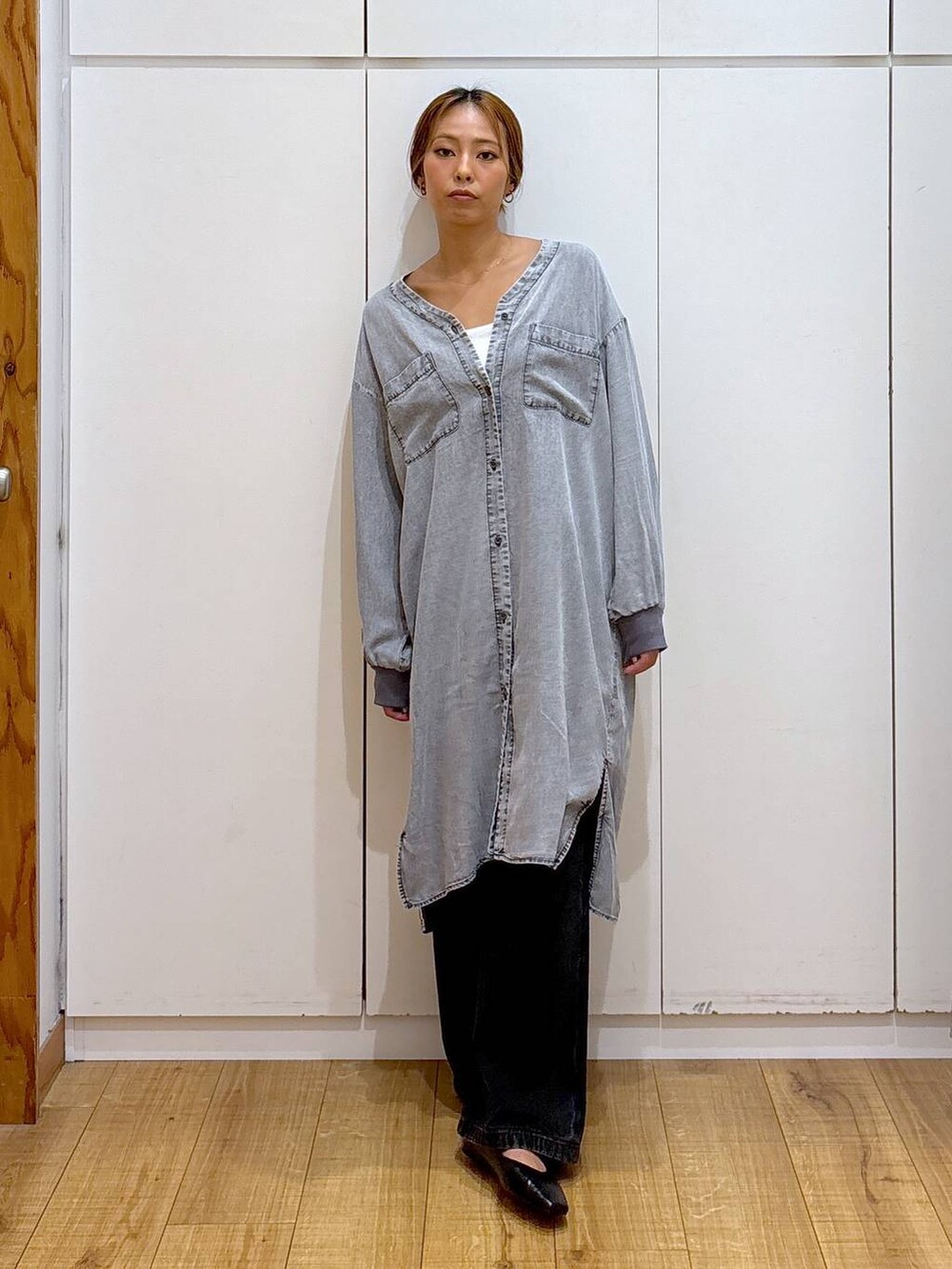 ブラック系のパンプス、ホワイト系のキャミソール、ブラック系のデニムパンツを着用したレディースの秋コーディネートの2枚目の写真