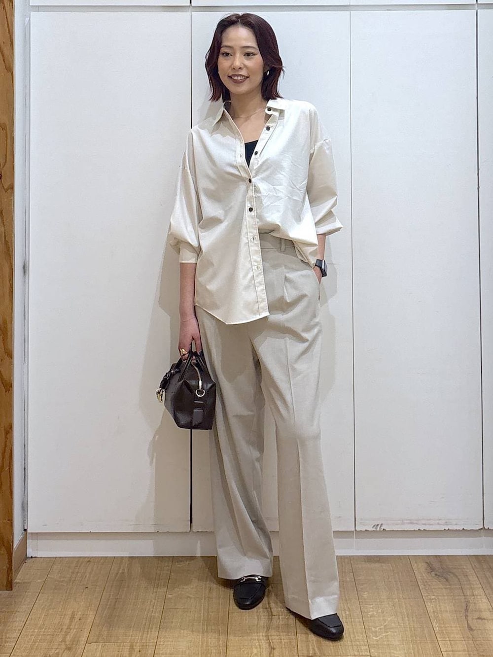 ブラック系のローファー、ベージュ系のシャツ/ブラウス、ベージュ系のスラックスを着用したレディースの春コーディネートの3枚目の写真