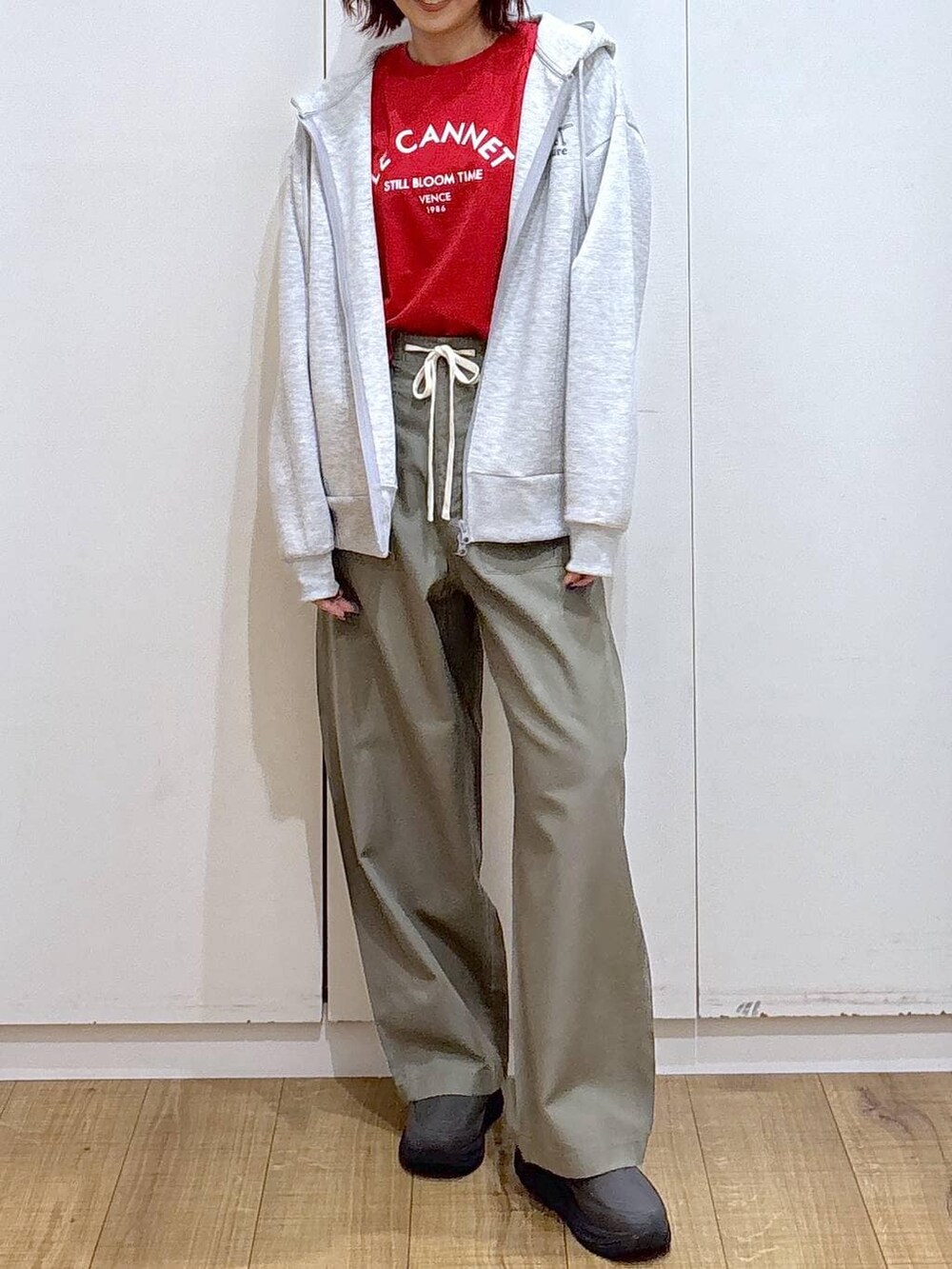 レッド系のTシャツ/カットソー、グリーン系のその他パンツ、グレー系のパーカーを着用したレディースの春コーディネートの3枚目の写真