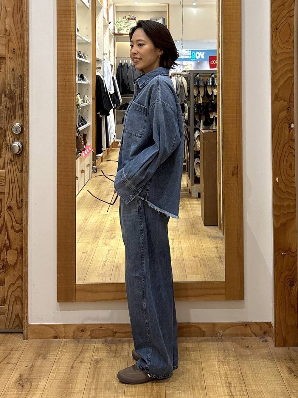 ブラウン系のスニーカー、ブルー系のシャツ/ブラウス、ブルー系のデニムパンツを着用したレディースの冬コーディネートの4枚目の写真