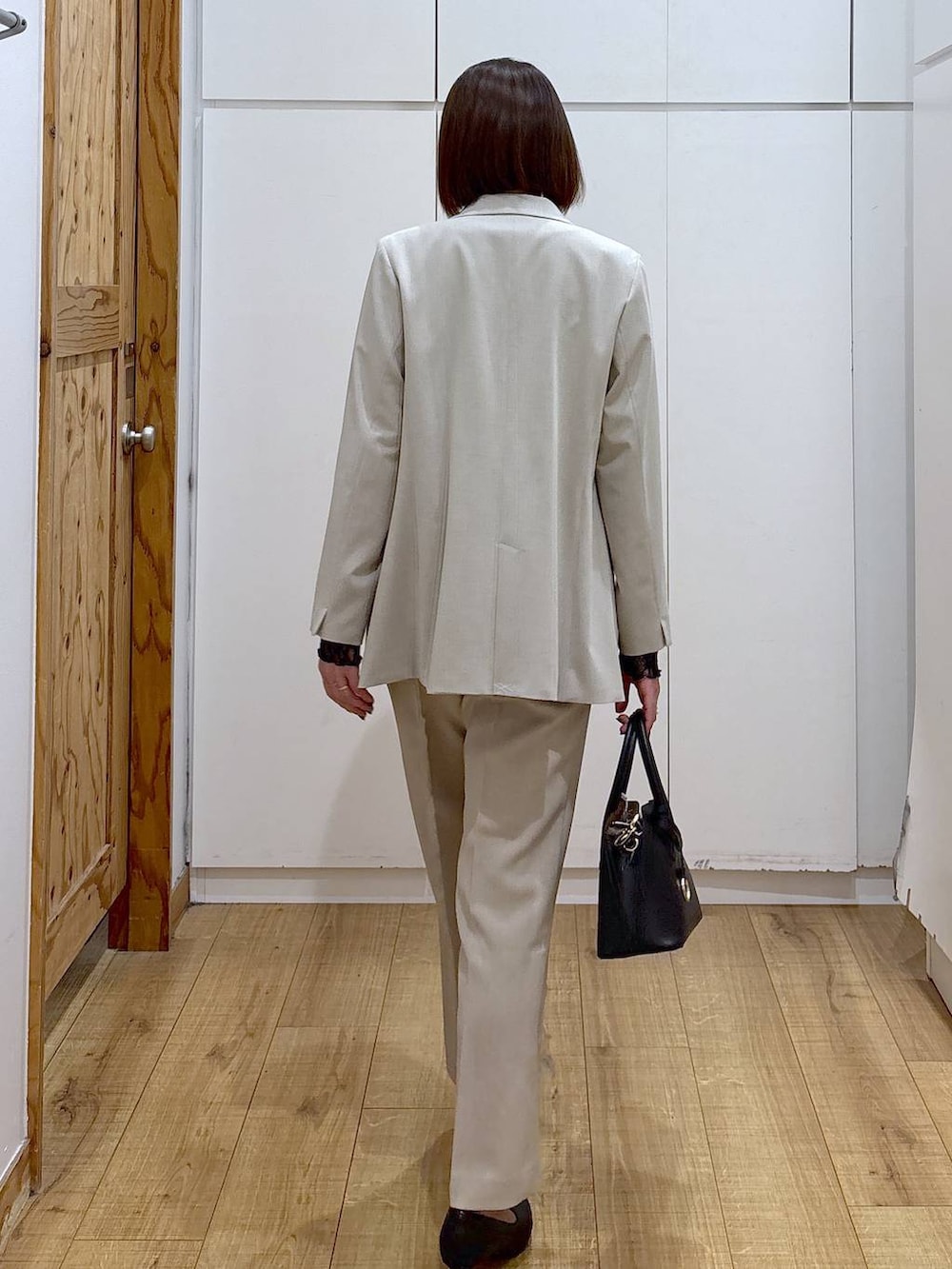 ブラック系のショルダーバッグ、ブラック系のパンプス、ブラック系のTシャツ/カットソーを着用したレディースの冬コーディネートの8枚目の写真