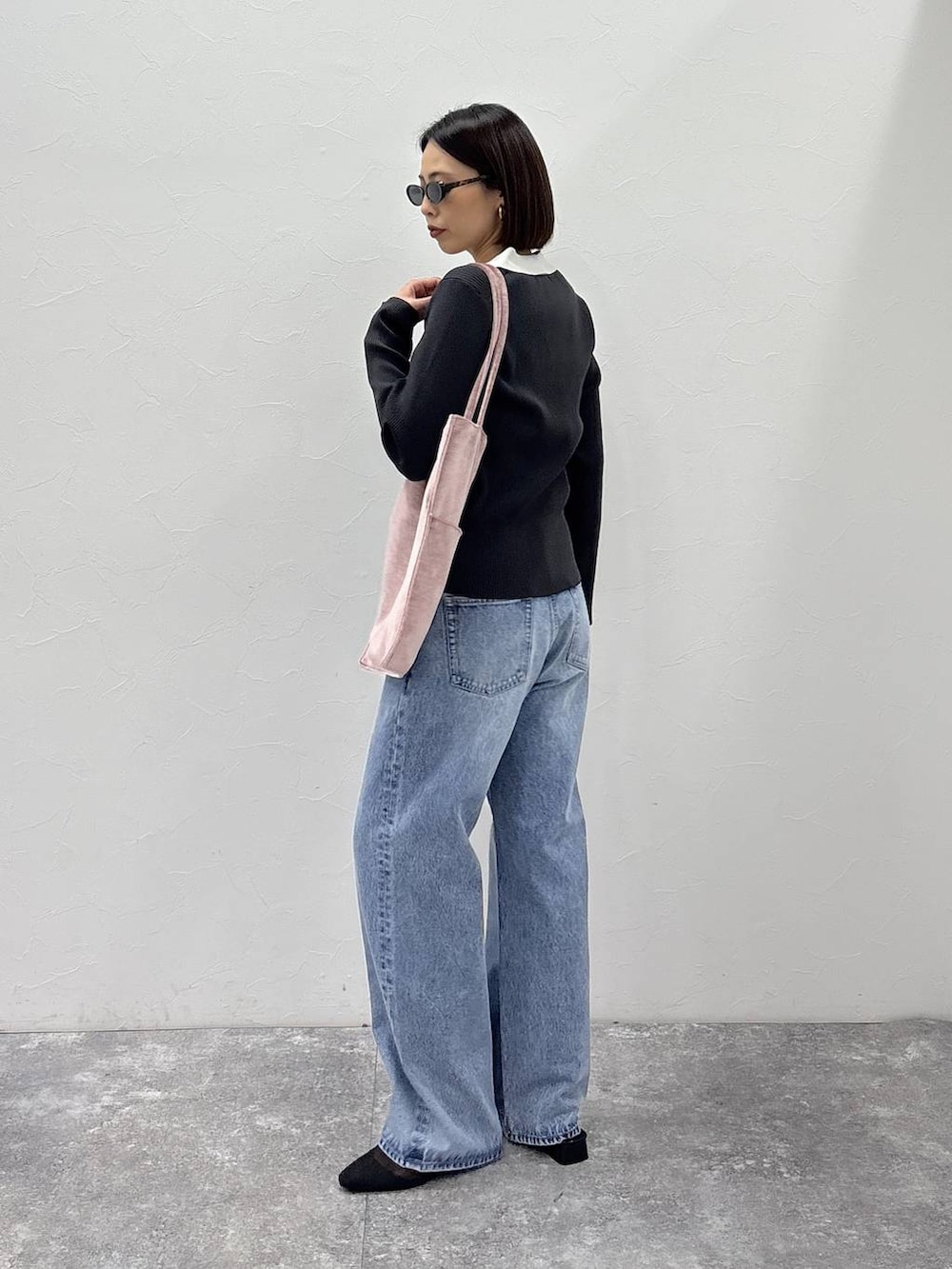 ピンク系のトートバッグ、グレー系のニット/セーター、ゴールド系のピアス（両耳用）を着用したレディースの冬コーディネートの6枚目の写真