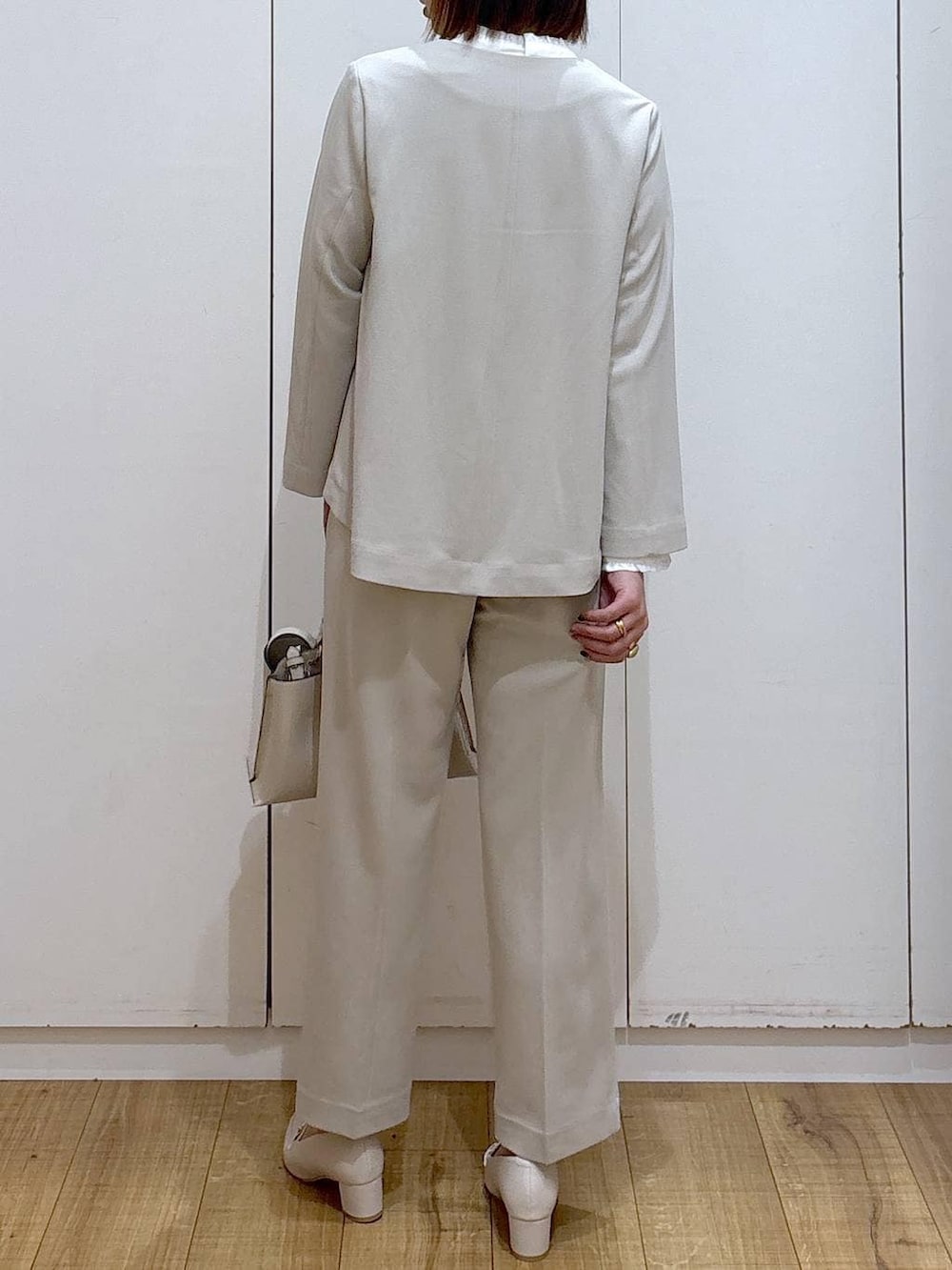 ベージュ系のセットアップ、ベージュ系のショルダーバッグ、ホワイト系のローファーを着用したレディースの冬コーディネートの5枚目の写真