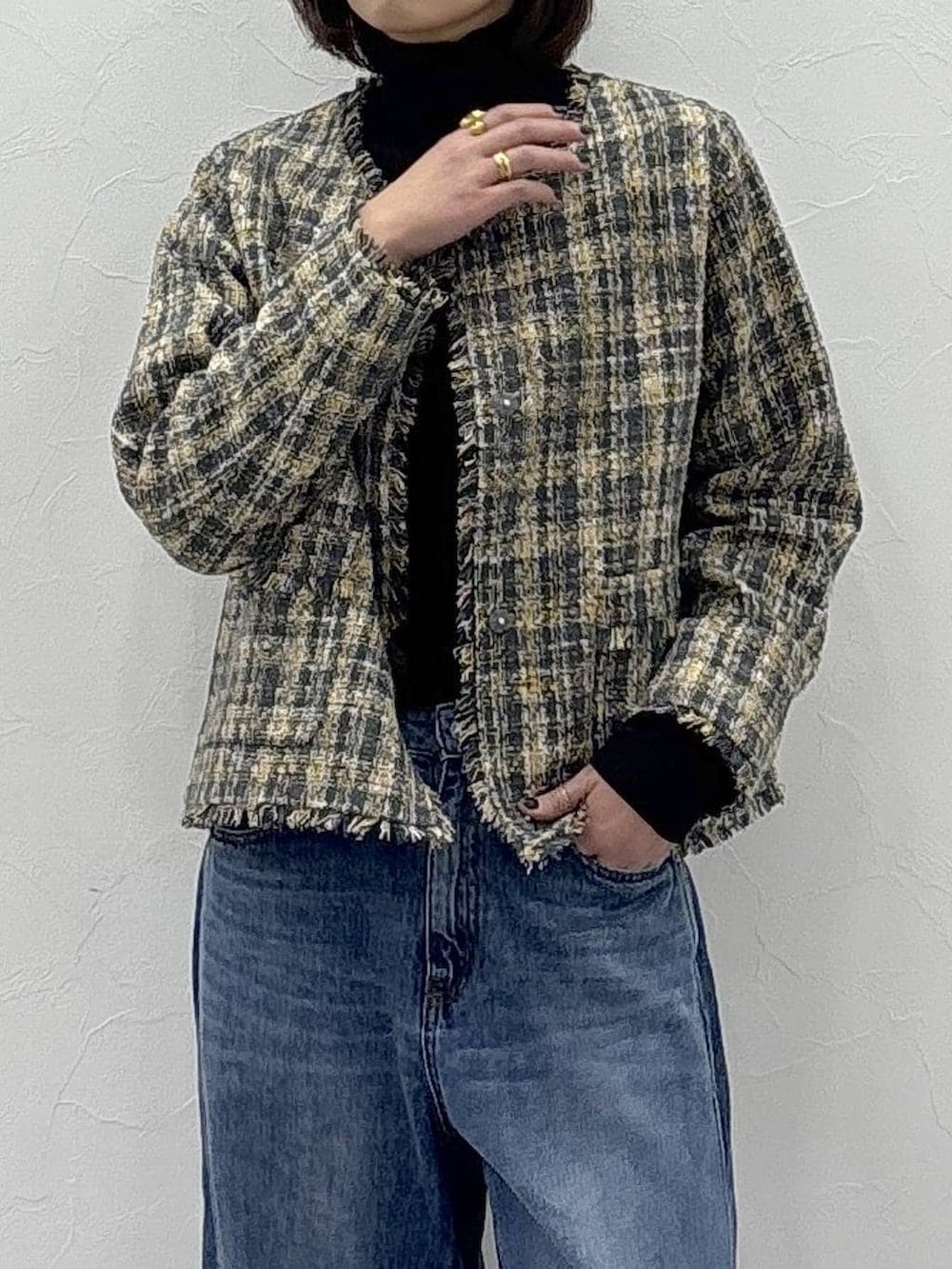 ブラック系のニット/セーター、ブラック系のブーツ、ブルー系のデニムパンツを着用したレディースの冬コーディネートの8枚目の写真