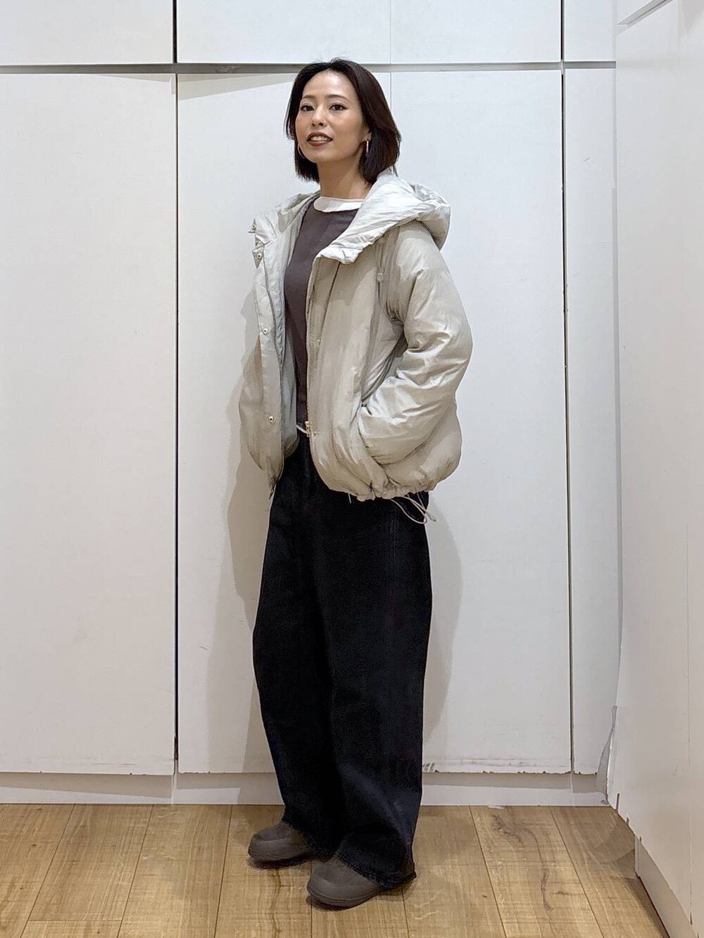 ベージュ系のダウンジャケット/コート、ブラック系のデニムパンツ、グリーン系のその他シューズを着用したレディースの秋コーディネートの2枚目の写真