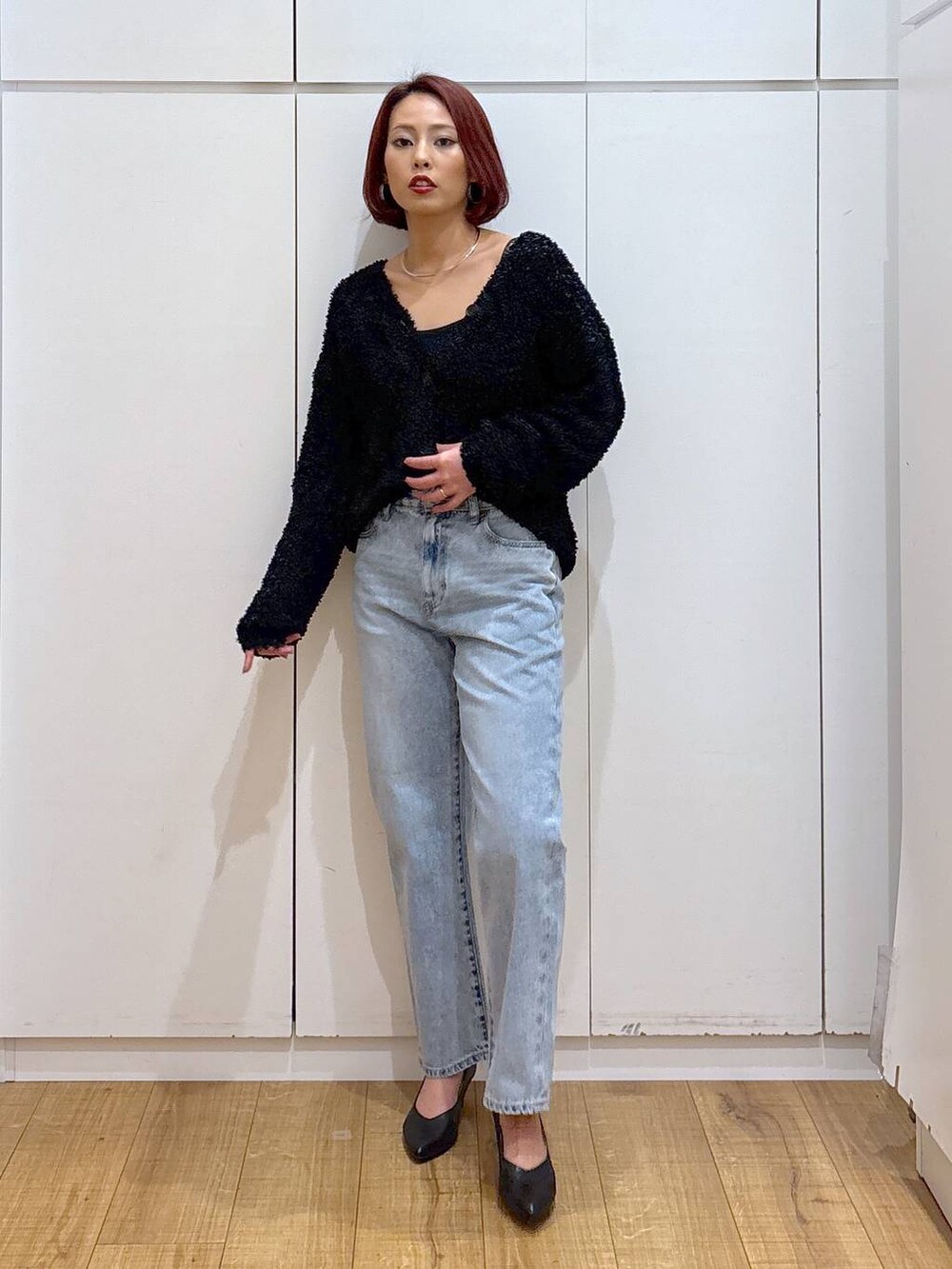 ブルー系のデニムパンツ、ブラック系のパンプス、ブラック系のカーディガン/ボレロを着用したレディースの春コーディネートの2枚目の写真