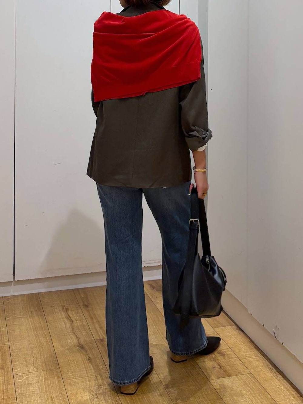 レッド系のカーディガン/ボレロ、ホワイト系のTシャツ/カットソー、ブルー系のデニムパンツを着用したレディースの秋コーディネートの4枚目の写真