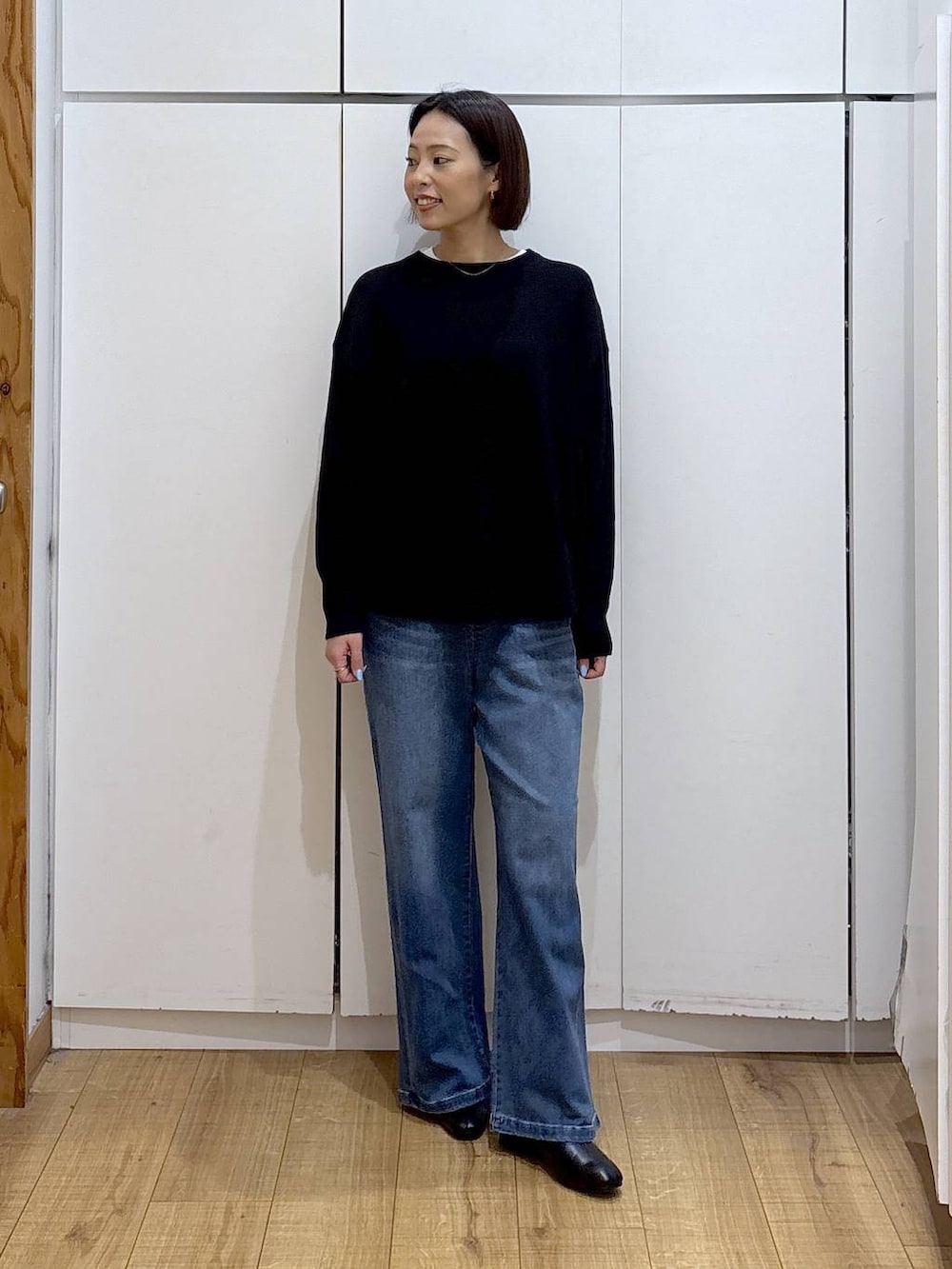 ブラック系のニット/セーター、ブラウン系のダウンジャケット/コート、ホワイト系のTシャツ/カットソーを着用したレディースの冬コーディネートの8枚目の写真