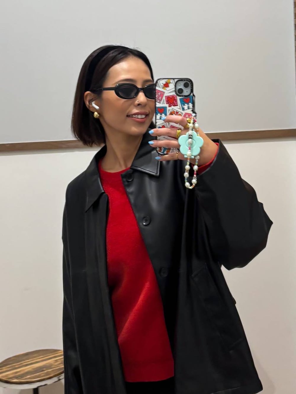 ブラック系のブルゾン、レッド系のニット/セーター、ブラック系のカチューシャを着用したレディースの秋コーディネートの2枚目の写真