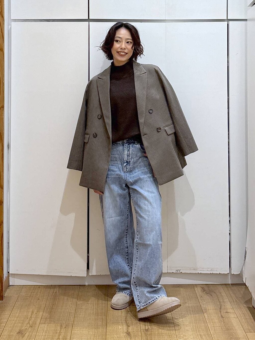 ブルー系のデニムパンツ、ブラウン系のニット/セーター、ブラウン系のテーラードジャケットを着用したレディースの冬コーディネートの5枚目の写真