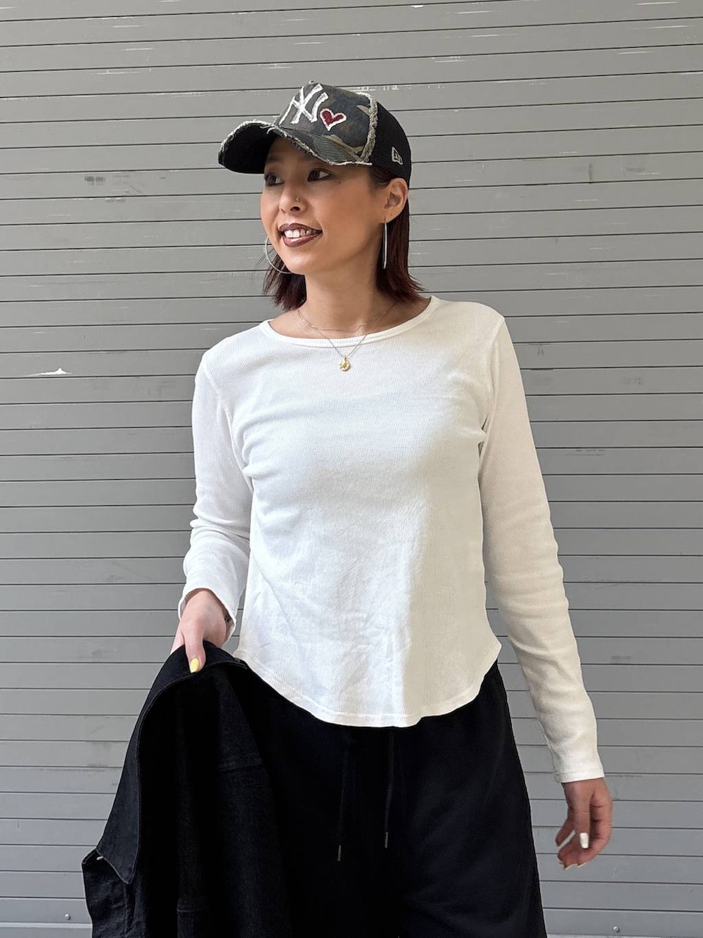 ブラック系のデニムジャケット、ブラック系のスウェットパンツ、ゴールド系のネックレスを着用したレディースの春コーディネートの9枚目の写真