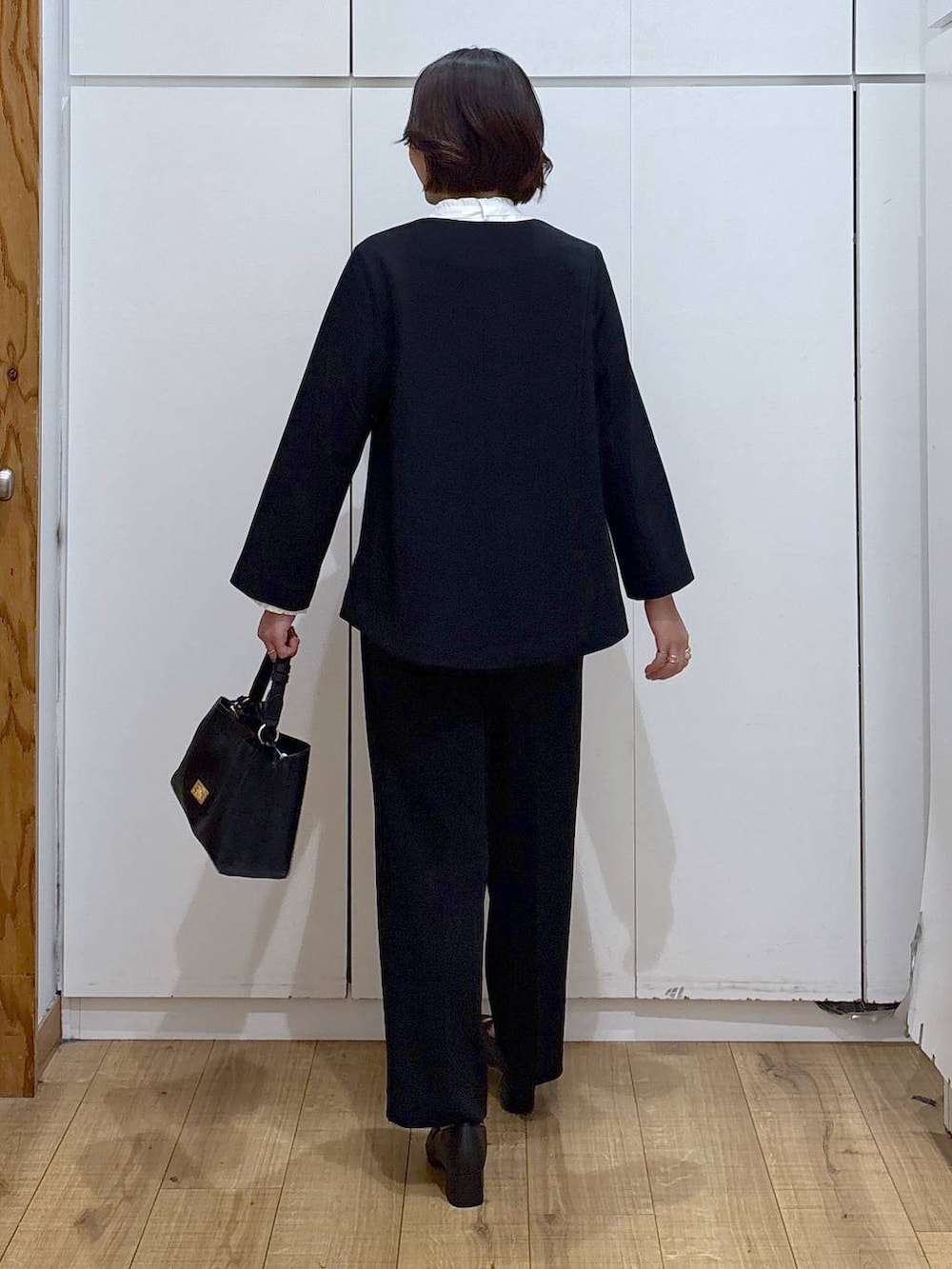 ブラック系のローファー、ブラック系のセットアップ、ブラック系のショルダーバッグを着用したレディースの冬コーディネートの5枚目の写真