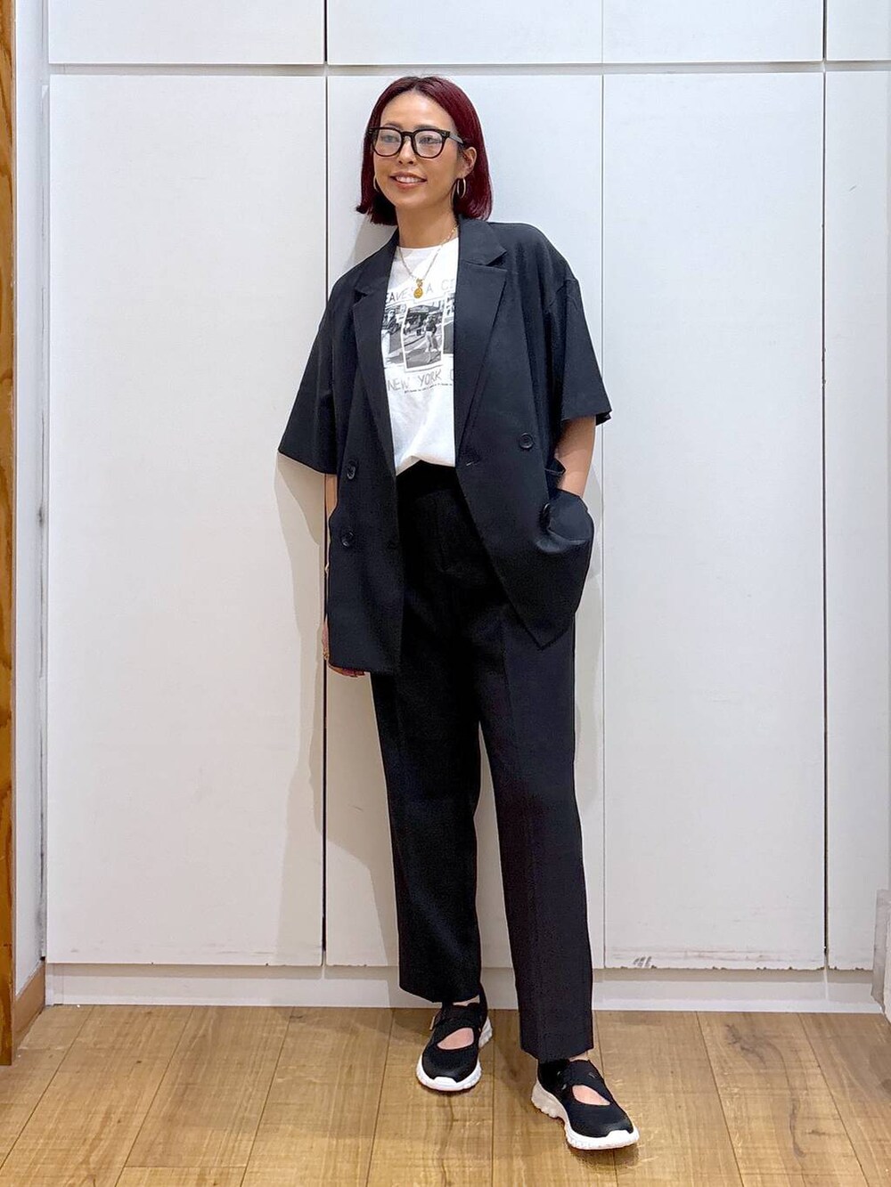 ブラック系のスニーカー、ブラック系のテーラードジャケット、ホワイト系のTシャツ/カットソーを着用したレディースの春コーディネートの2枚目の写真