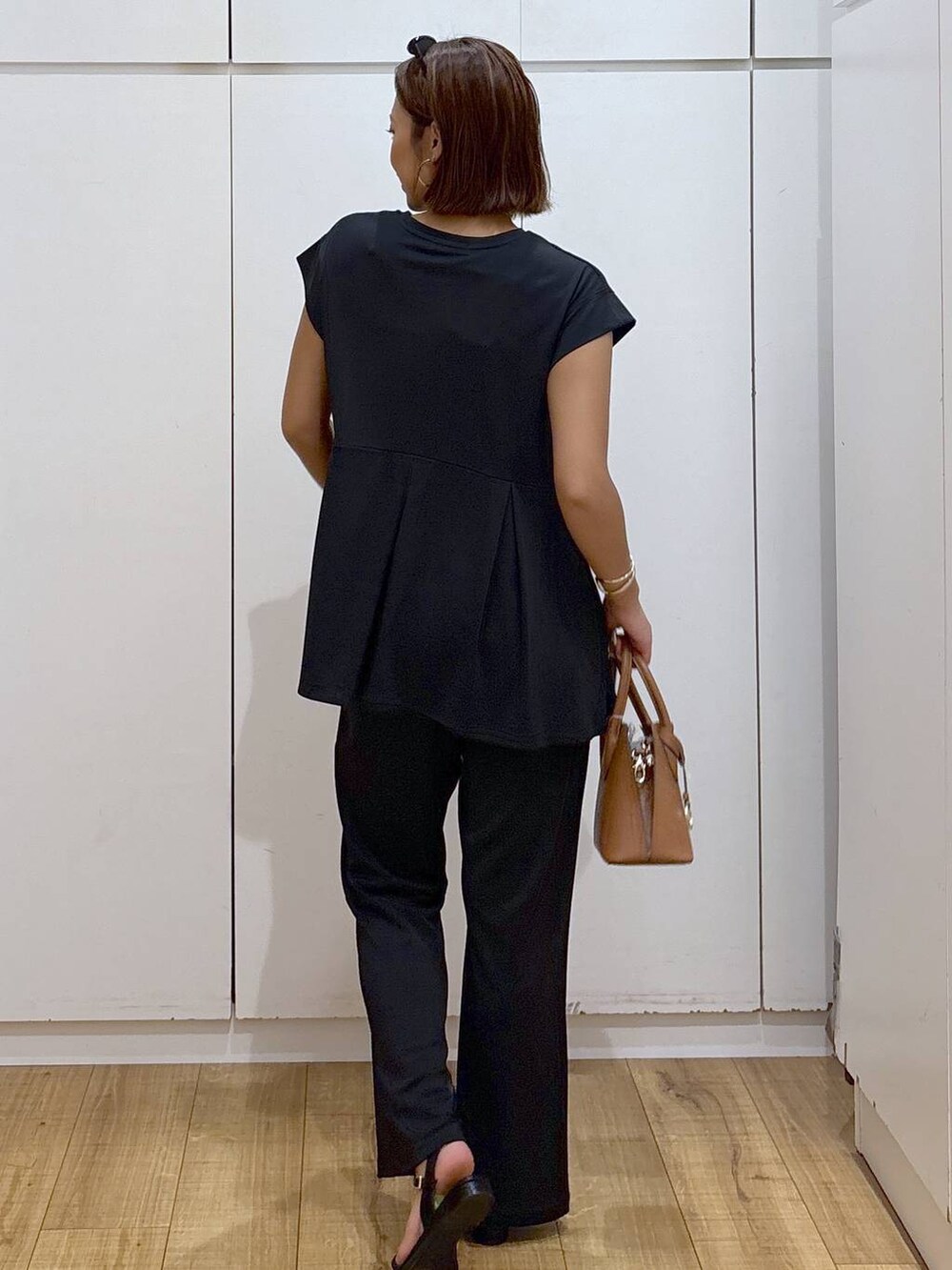 ブラウン系のショルダーバッグ、ブラック系のTシャツ/カットソー、ブラック系のその他パンツを着用したレディースの夏コーディネートの4枚目の写真