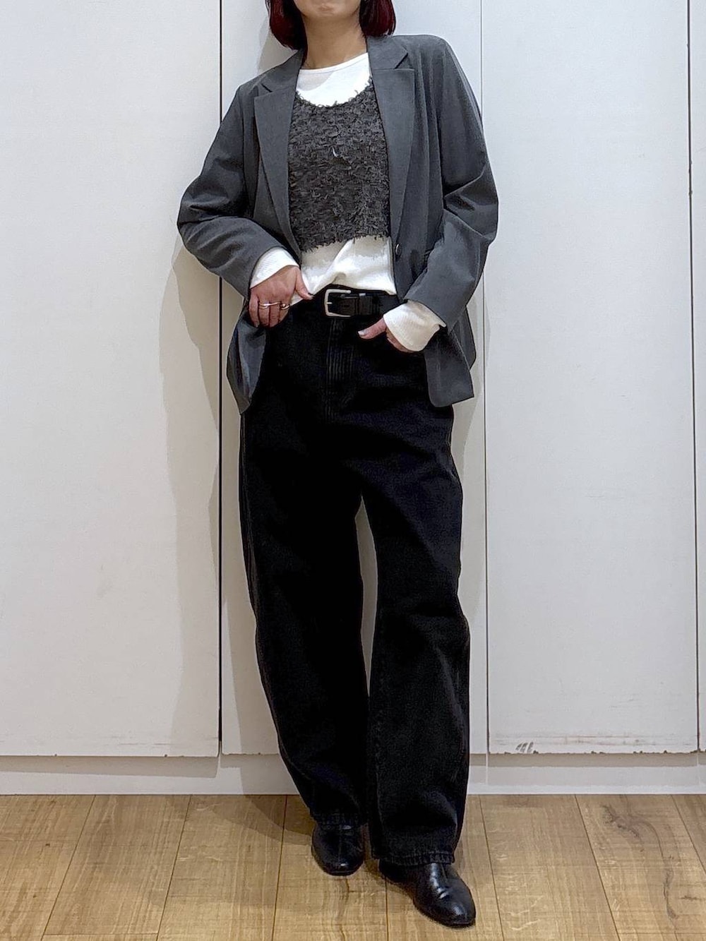 グレー系のテーラードジャケット、ブラック系のブーツ、ブラック系のデニムパンツを着用したレディースの春コーディネートの2枚目の写真