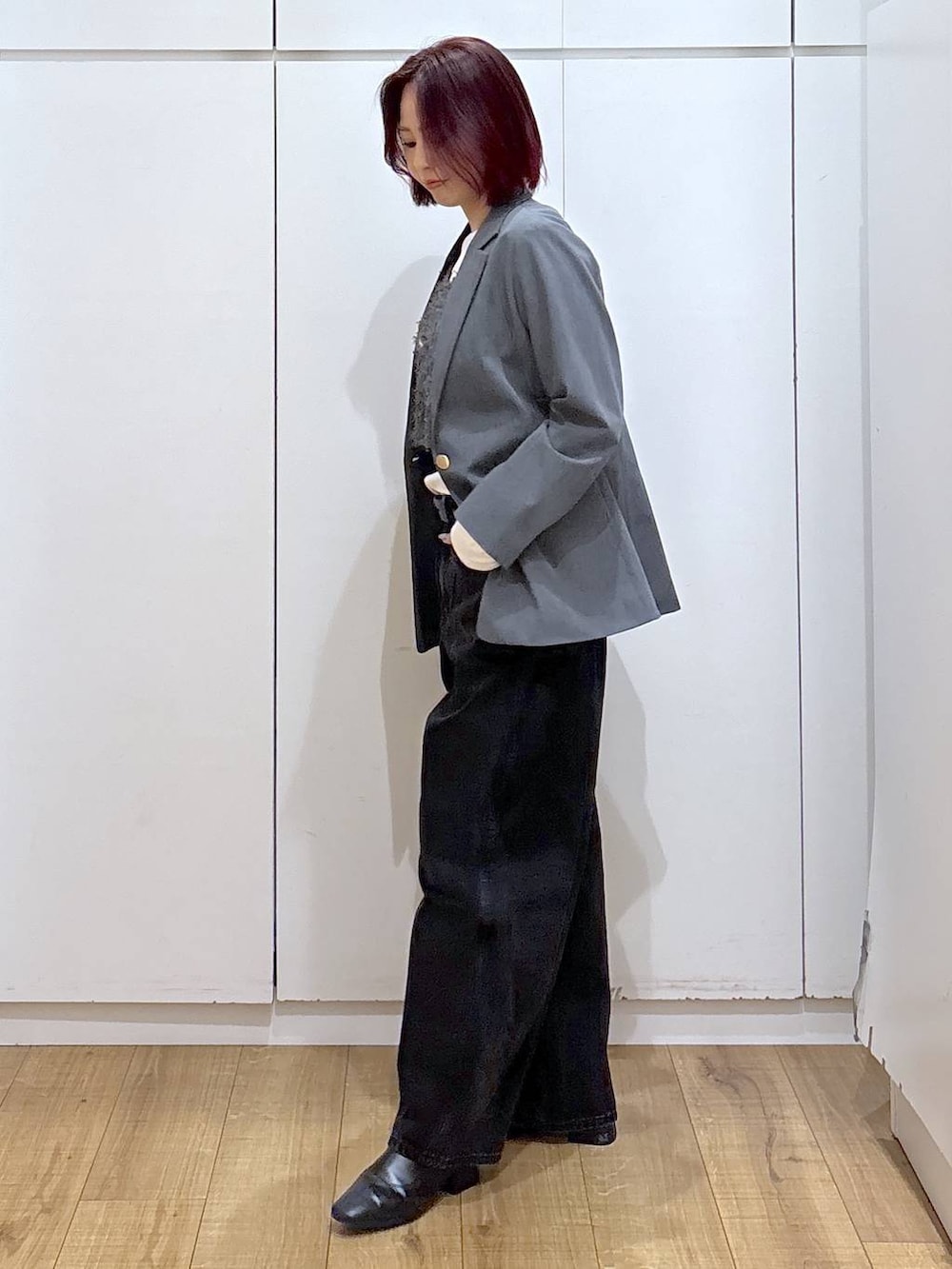 グレー系のテーラードジャケット、ブラック系のブーツ、ブラック系のデニムパンツを着用したレディースの春コーディネートの5枚目の写真