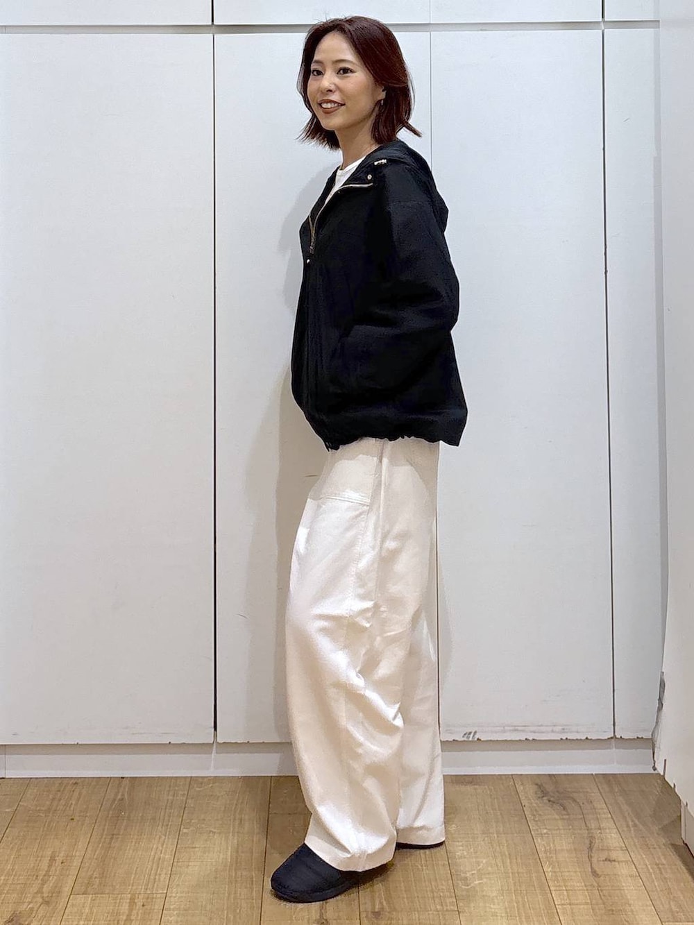 ブラック系のマウンテンパーカー、ベージュ系のその他パンツ、ゴールド系のネックレスを着用したレディースの春コーディネートの3枚目の写真