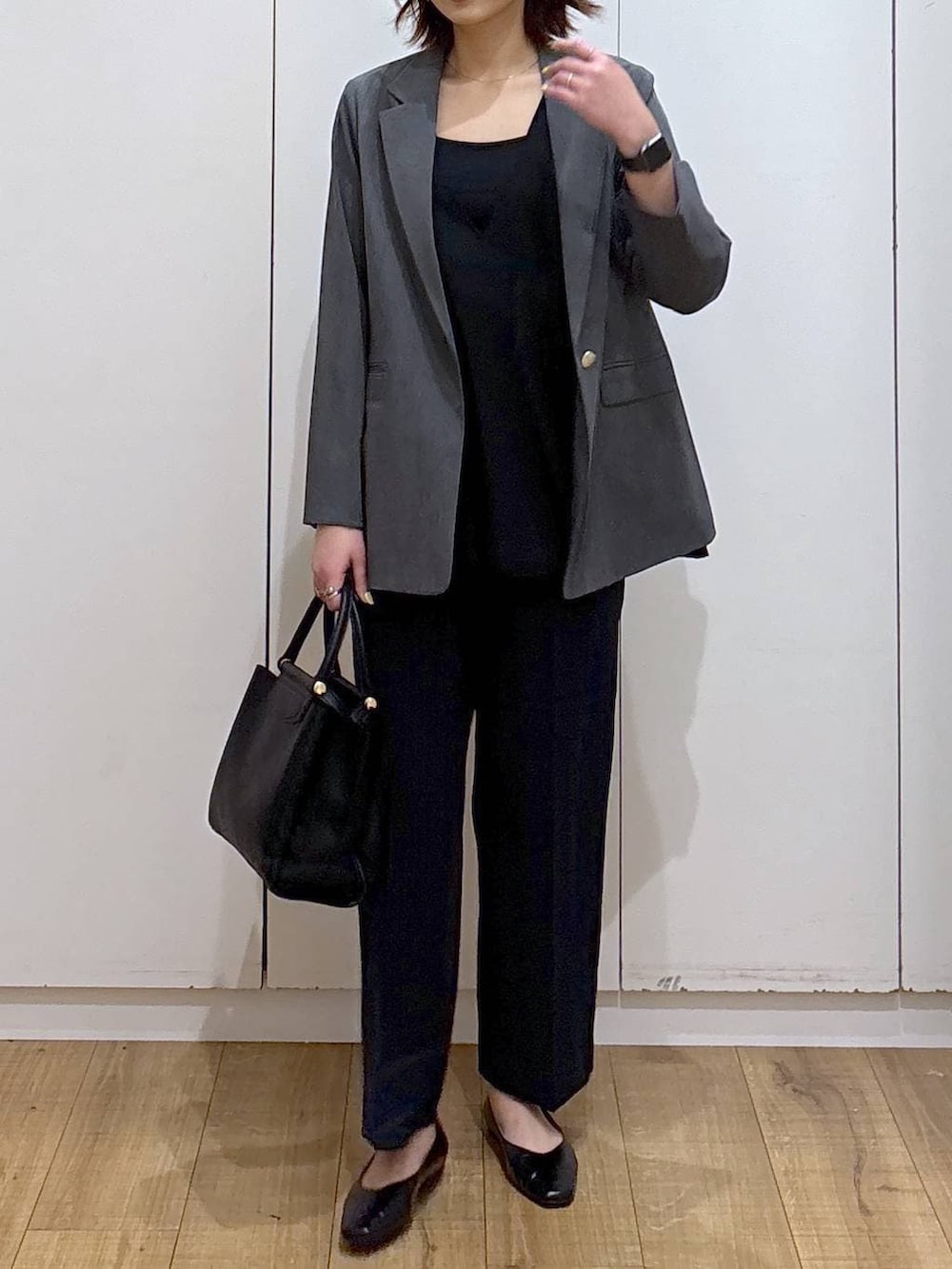 ブラック系のパンプス、ブラック系のセットアップ、ブラック系のトートバッグを着用したレディースの春コーディネートの4枚目の写真