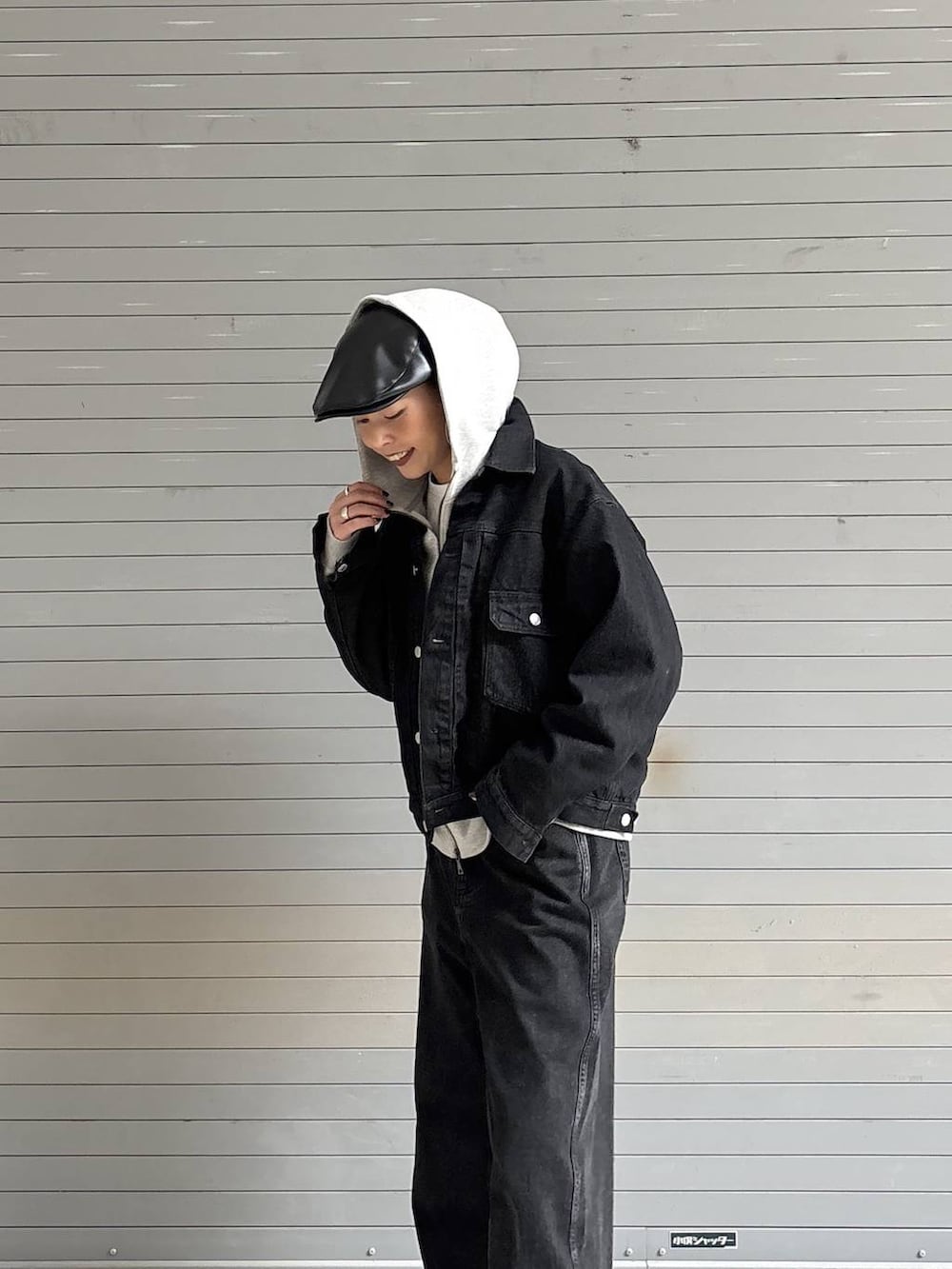 ブラック系のデニムパンツ、ブラック系のデニムジャケット、グレー系のパーカーを着用したレディースの冬コーディネートの6枚目の写真