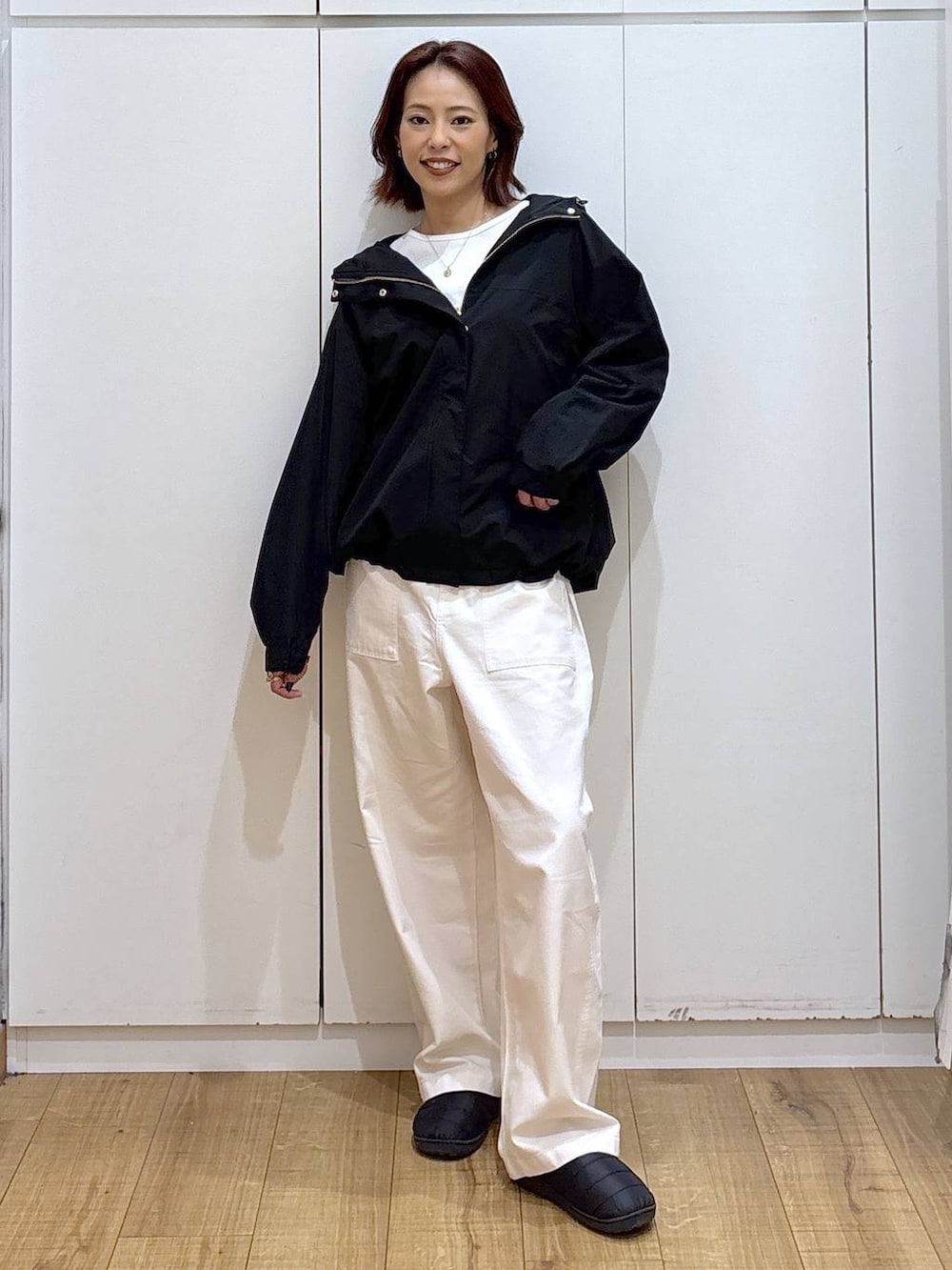 ブラック系のマウンテンパーカー、ベージュ系のその他パンツ、ゴールド系のネックレスを着用したレディースの春コーディネートの2枚目の写真