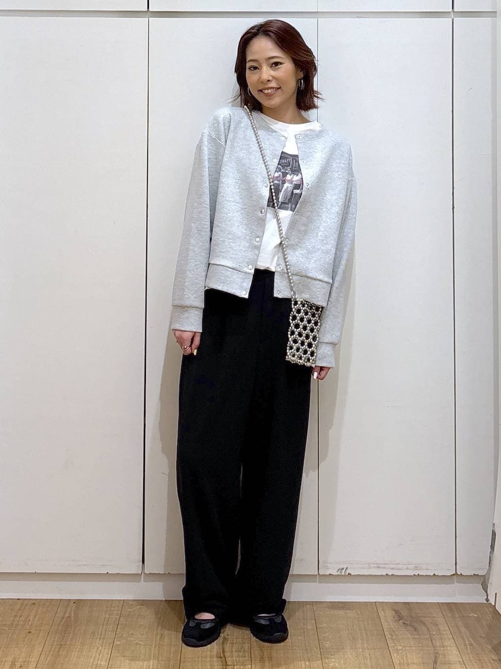ブラック系のその他パンツ、グレー系のカーディガン/ボレロ、ホワイト系のTシャツ/カットソーを着用したレディースの春コーディネートの2枚目の写真