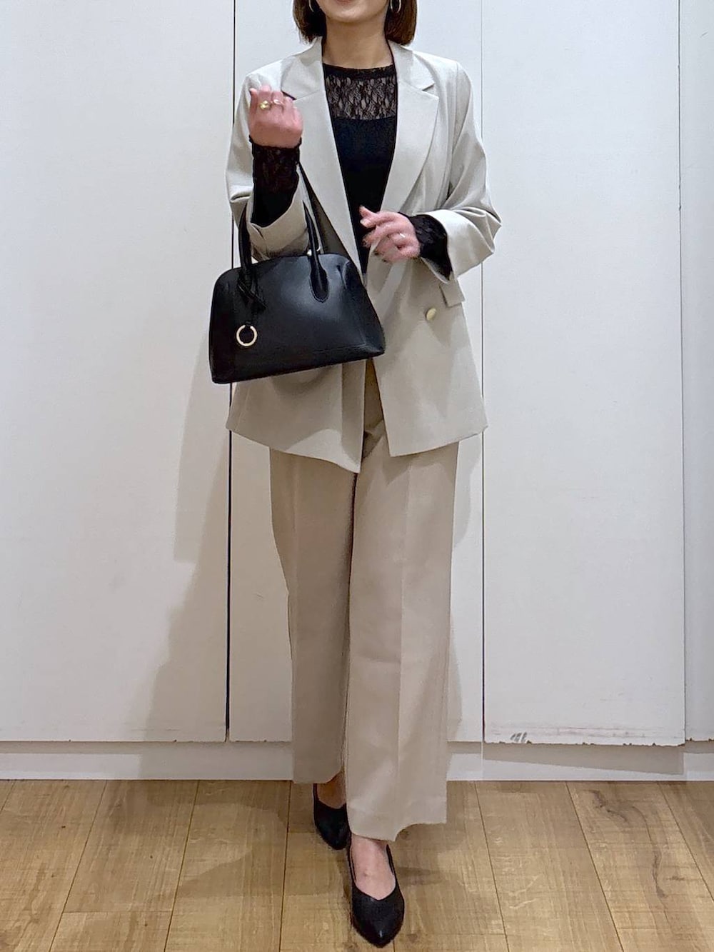 ブラック系のショルダーバッグ、ブラック系のパンプス、ブラック系のTシャツ/カットソーを着用したレディースの冬コーディネートの4枚目の写真