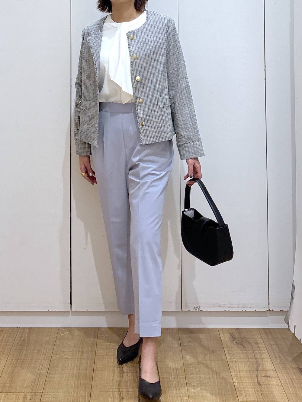 ブラック系のパンプス、ブルー系のスラックス、ホワイト系のシャツ/ブラウスを着用したレディースの冬コーディネートの3枚目の写真