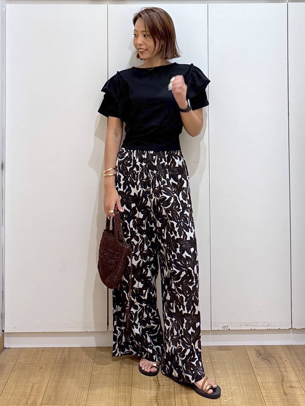 ベージュ系のその他パンツ、ブラウン系のクラッチバッグ、ブラック系のTシャツ/カットソーを着用したレディースの夏コーディネートの3枚目の写真