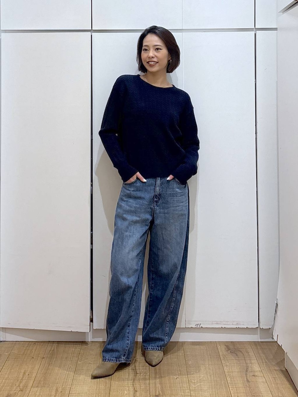 ブルー系のニット/セーター、ベージュ系のブーツ、ブルー系のデニムパンツを着用したレディースの冬コーディネートの4枚目の写真