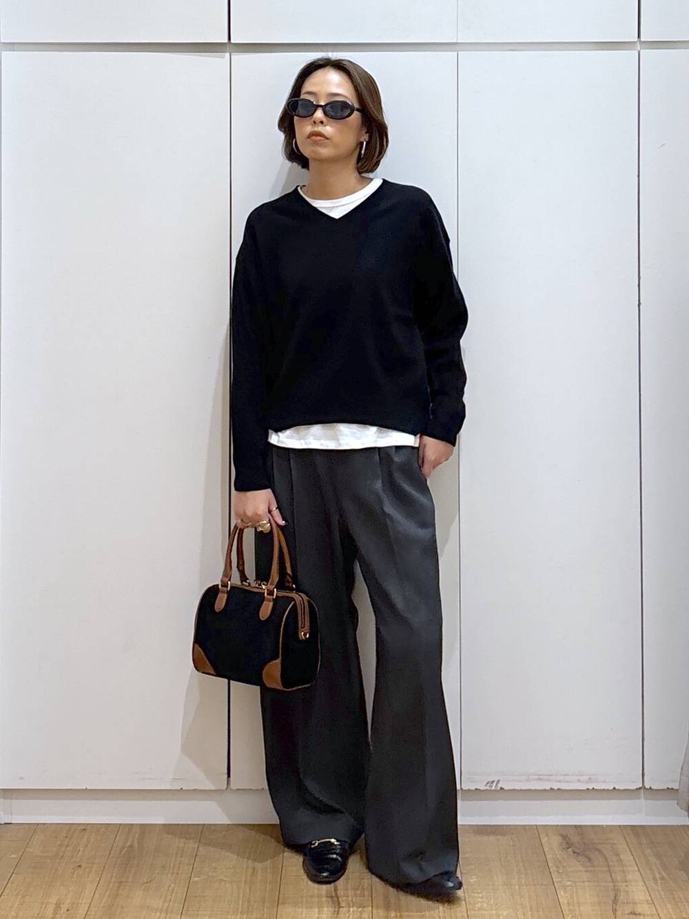 ブラック系のローファー、ブラック系のスウェット、グレー系のその他パンツを着用したレディースの秋コーディネートの7枚目の写真