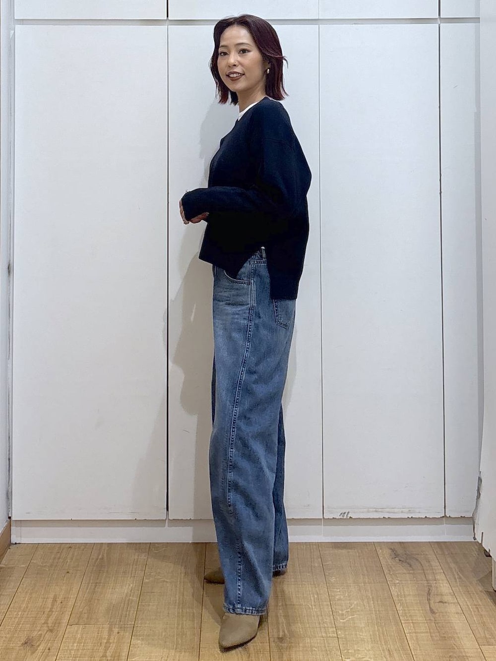 ブルー系のデニムパンツ、ブルー系のニット/セーター、ゴールド系のリングを着用したレディースの春コーディネートの3枚目の写真