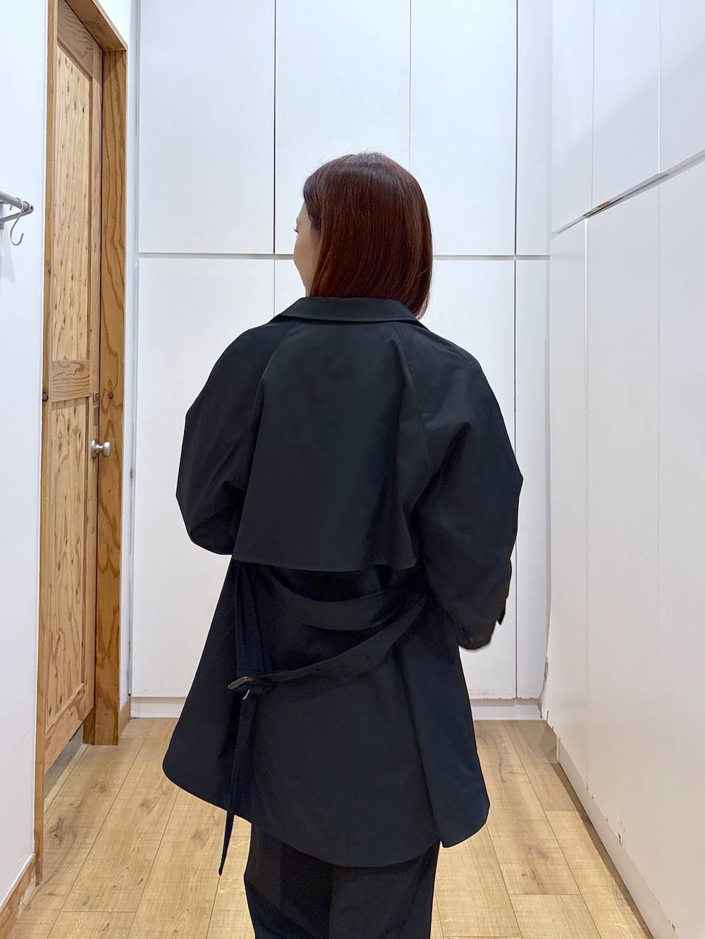 ブラック系のローファー、ブラック系のスラックス、ブルー系のトレンチコートを着用したレディースの春コーディネートの2枚目の写真