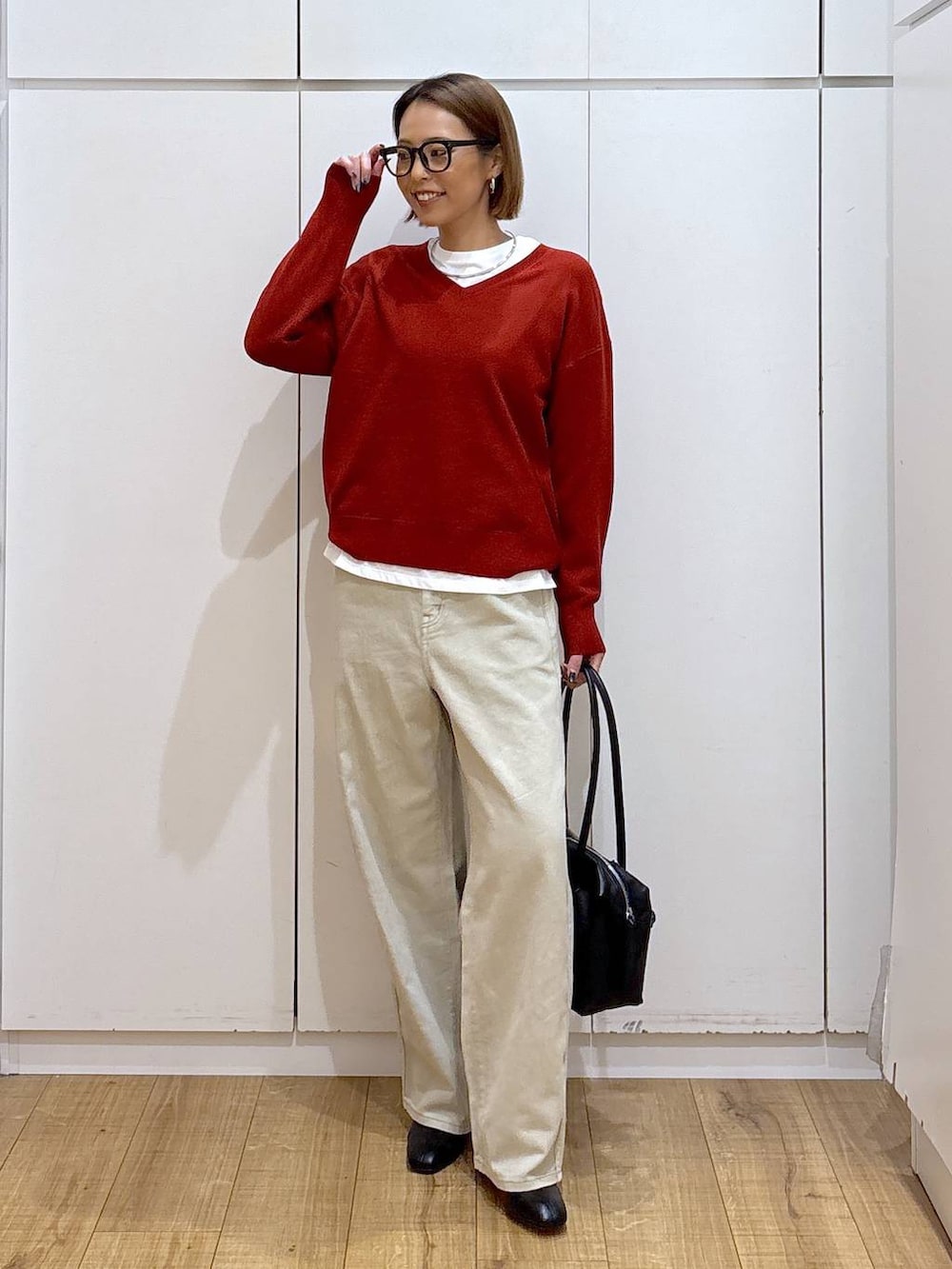 ブラック系のボストンバッグ、ベージュ系のデニムパンツ、ホワイト系のTシャツ/カットソーを着用したレディースの秋コーディネートの2枚目の写真