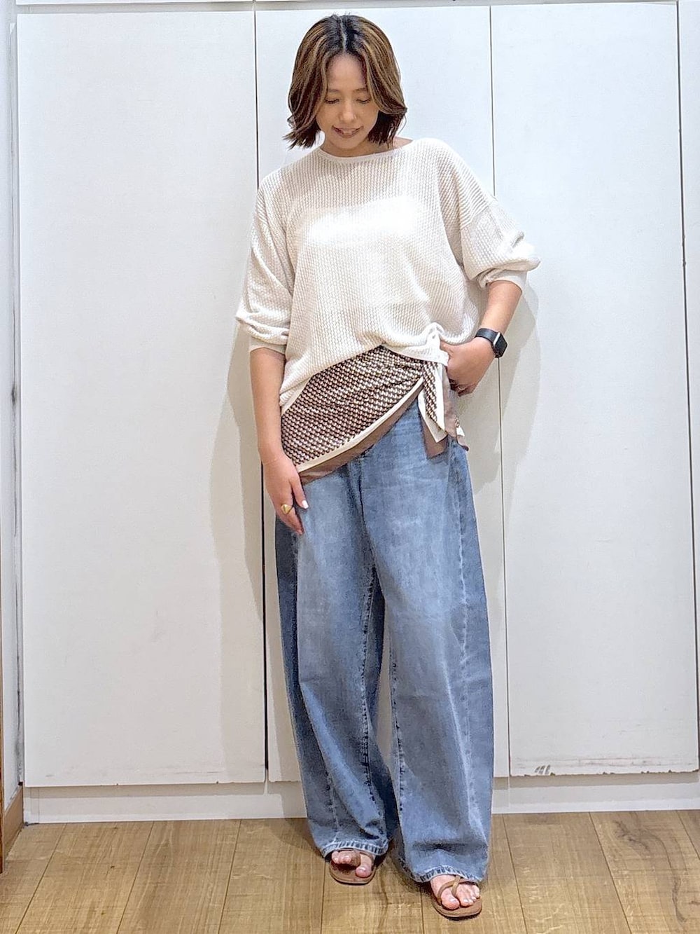 ホワイト系のキャミソール、ブルー系のデニムパンツ、ホワイト系のニット/セーターを着用したレディースの春コーディネートの3枚目の写真