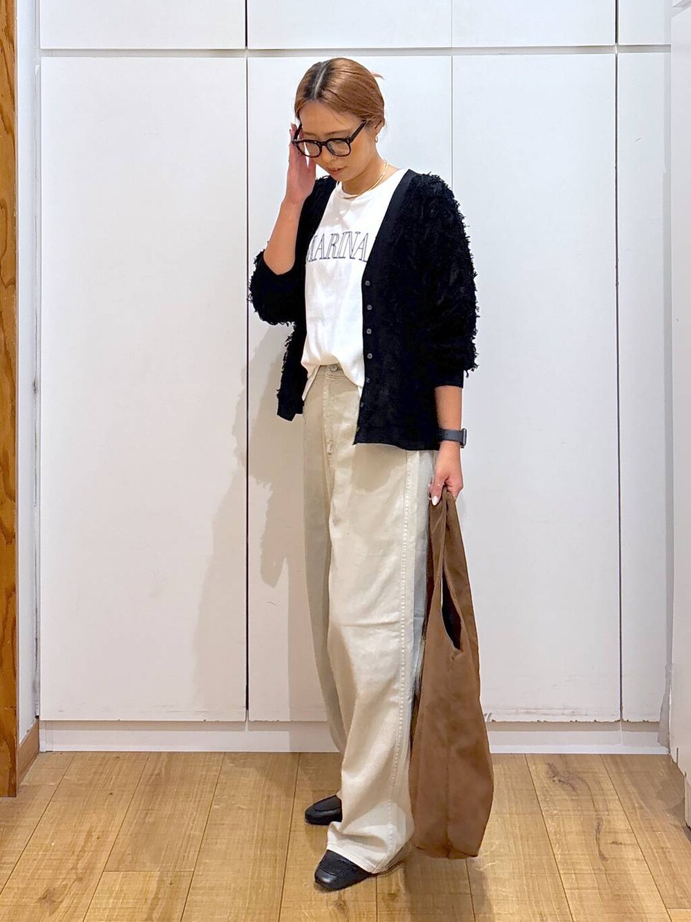 ブラック系のローファー、ホワイト系のTシャツ/カットソー、ベージュ系のデニムパンツを着用したレディースの秋コーディネートの4枚目の写真