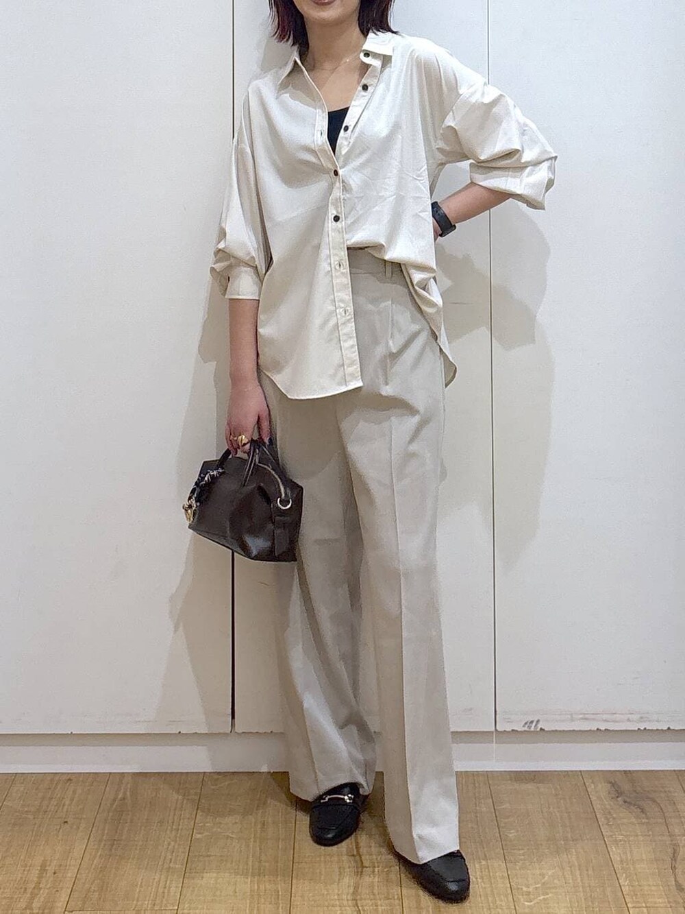 ブラック系のローファー、ベージュ系のシャツ/ブラウス、ベージュ系のスラックスを着用したレディースの春コーディネートの2枚目の写真