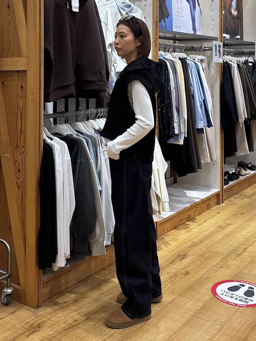 ブルー系のデニムパンツ、ブラック系のベストを着用したレディースの冬コーディネートの4枚目の写真