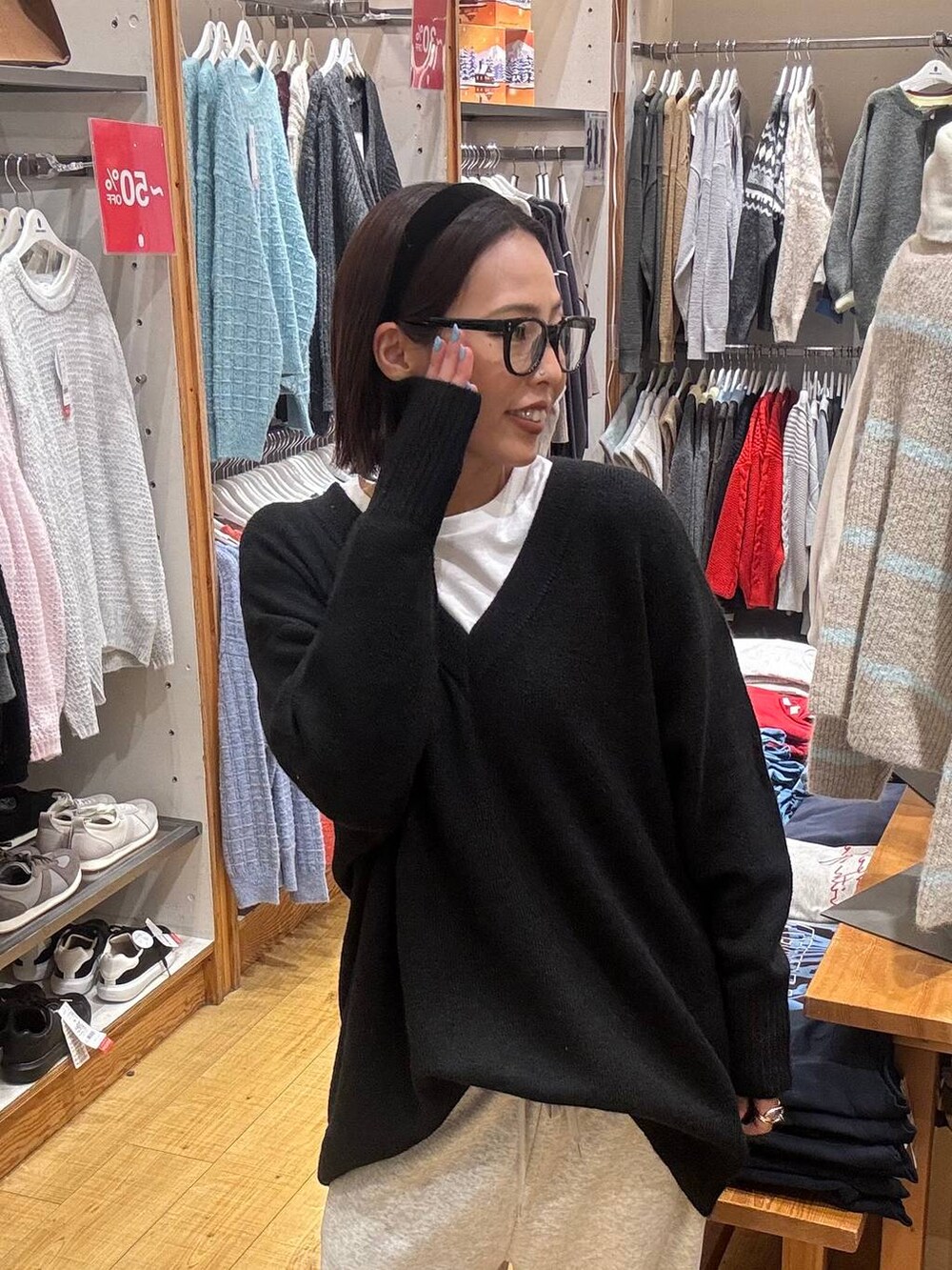 ブラック系のボストンバッグ、ブラック系のニット/セーター、ホワイト系のTシャツ/カットソーを着用したレディースの冬コーディネートの6枚目の写真