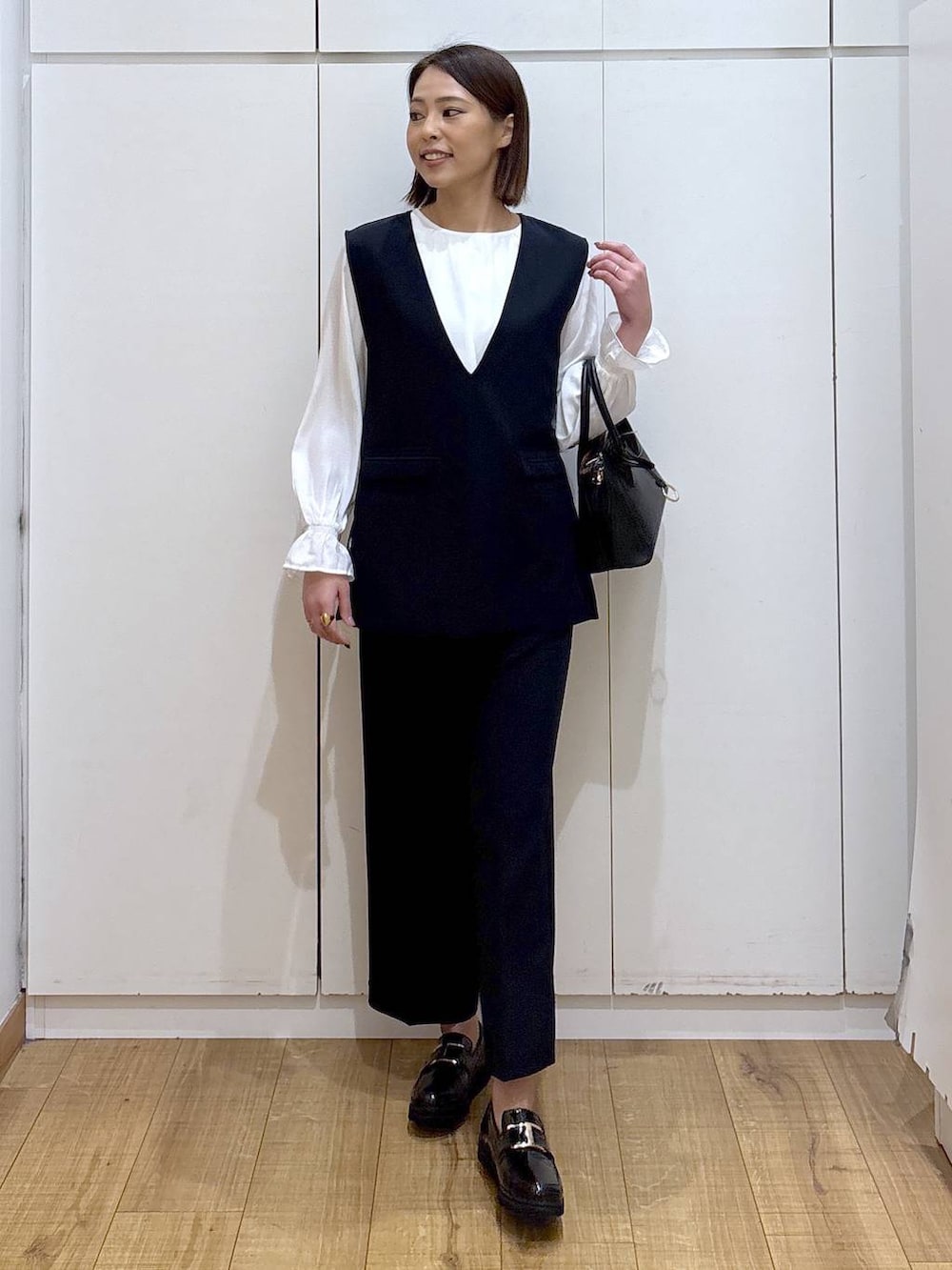 ブラック系のローファー、ブラック系のショルダーバッグ、ブルー系のセットアップを着用したレディースの冬コーディネートの7枚目の写真