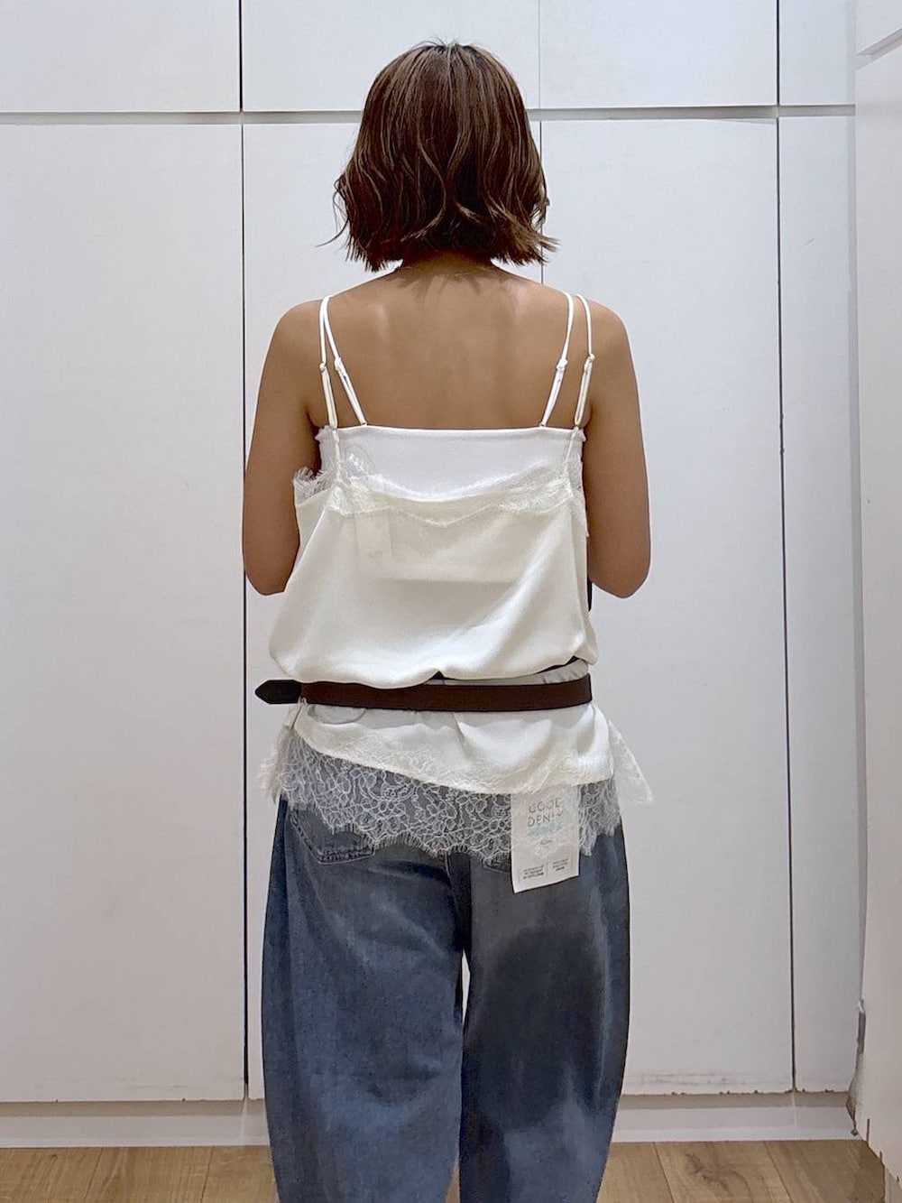 ホワイト系のキャミソール、ブルー系のデニムパンツ、ホワイト系のキャミソールを着用したレディースの春コーディネートの6枚目の写真