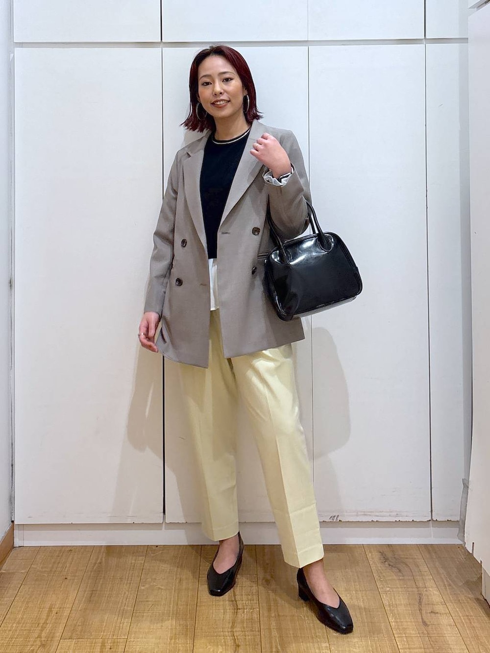 イエロー系のその他パンツ、ブラック系のボストンバッグ、ブラック系のニット/セーターを着用したレディースの春コーディネートの2枚目の写真